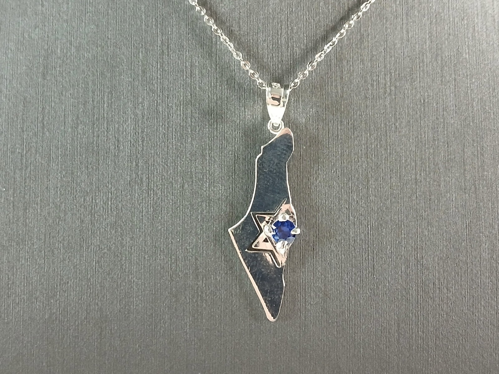 Sterling Silver Jewish Judaica Star of David Israel Pendant Necklace: A STERLING SILVER JUDAICA STAR OF DAVID PENDANT IN THE SHAPE OF ISRAEL. THE PENDANT WITH NECKLACE WEIGHS 3.3g. THE NECKLACE MEASURES 18" LONG AND IS ADJUSTABLE TO 16" LONG. THE PENDANT MEASURES 1 1/2"