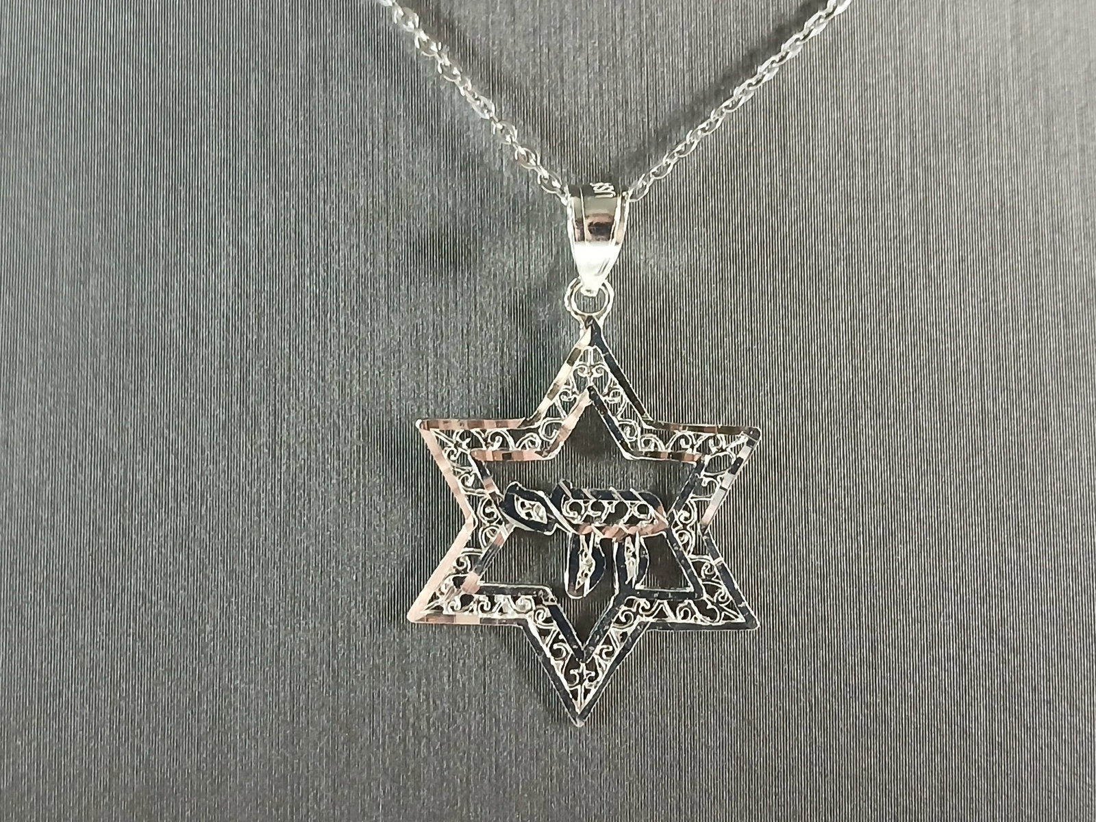 Sterling Silver Jewish Judaica Star of David Chai Pendant Necklace: A STERLING SILVER STAR OF DAVID CHAI PENDANT WITH NECKLACE. THE PENDANT WITH NECKLACE WEIGHS 2.6g. THE NECKLACE MEASURES 18" LONG, AND IS ADJUSTABLE TO 16" LONG. THE PENDANT MEASURES 1 1/4" LONG BY 7/
