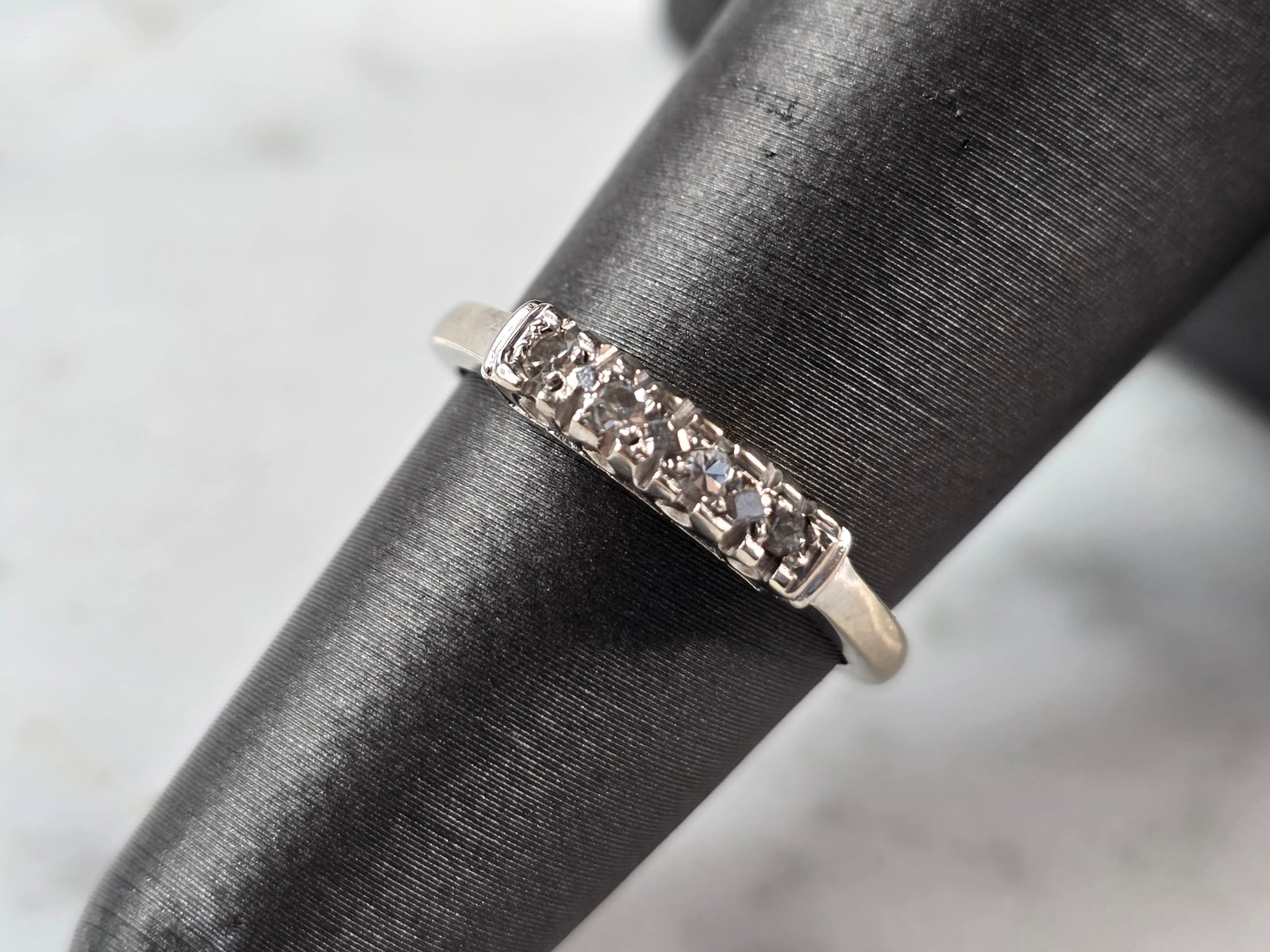 Womens Vintage Estate 14K White Gold Diamond Ring: A WOMENS VINTAGE ESTATE 14K WHITE GOLD DIAMOND RING. THE RING IS A SIZE 5.5 AND WEIGHS 2.2g. THERE ARE 4 SMALL DIAMONDS IN THIS RING. THE WIDTH OF THE RING IS 1/8". THE RING MAKES A BEAUTIFUL GIFT FOR