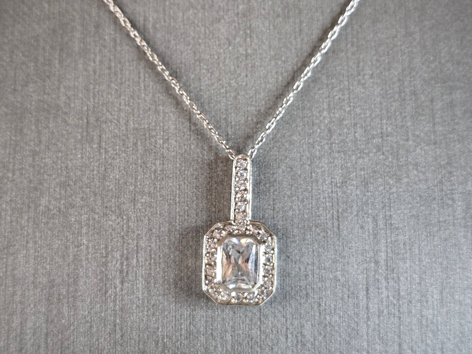 Womens Vintage Estate Sterling Silver CZ Pendant w/ Necklace: A WOMENS VINTAGE ESTATE STERLING SILVER CZ PENDANT WITH NECKLACE. TOGETHER THEY WEIGH 3.3g. THE PENDANT MEASURES 7/8" LONG BY 3/8" WIDE. THE NECKLACE MEASURES 18" LONG. MAKES A GREAT GIFT FOR THAT SOM