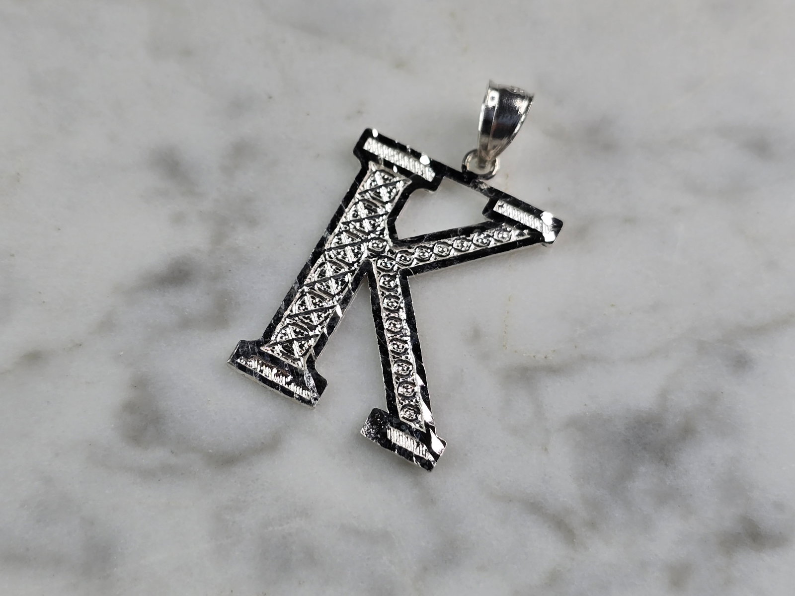 Womens Sterling Silver Initial Letter " K " Pendant: A WOMENS STERLING SILVER INITIAL LETTER "K" PENDANT. PENDANT WEIGHS 1.2g AND MEASURES 1 1/8" LONG BY 3/4" WIDE. MAKES A GREAT GIFT FOR THAT SOMEONE SPECIAL. ANY QUESTIONS, PLEASE ASK. BE SURE TO CHECK