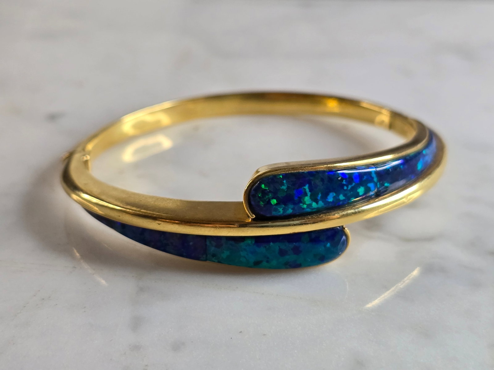 Womens Vintage Estate 18K Yellow Gold Blue Opal Bracelet: A VINTAGE WOMEN'S 18K YELLOW GOLD BLUE OPAL HINGED BANGLE BRACELET. BRACELET MEASURES 6 1/2" IN CIRCUMFERENCE BY 5/8" WIDE , AND WEIGHS 27.5g. BRACELET IS MARKED "750". THIS WOULD MAKE A LOVELY GIFT. 