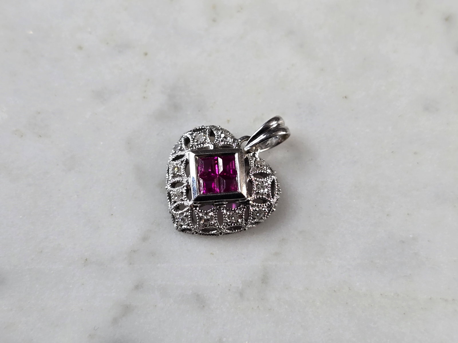 Womens Vintage Estate 14K White Gold Ruby Diamond Heart Pendant: A WOMENS VINTAGE ESTATE 14K WHITE GOLD RUBY DIAMOND HEART PENDANT. THE TOTAL WEIGHT IS 1.8g. THE PENDANT MEASURES 5/8" LONG BY 1/2" WIDE. THERE ARE 11 DIAMONDS AND 4 TINY RUBIES. MAKES A GREAT GIFT FO