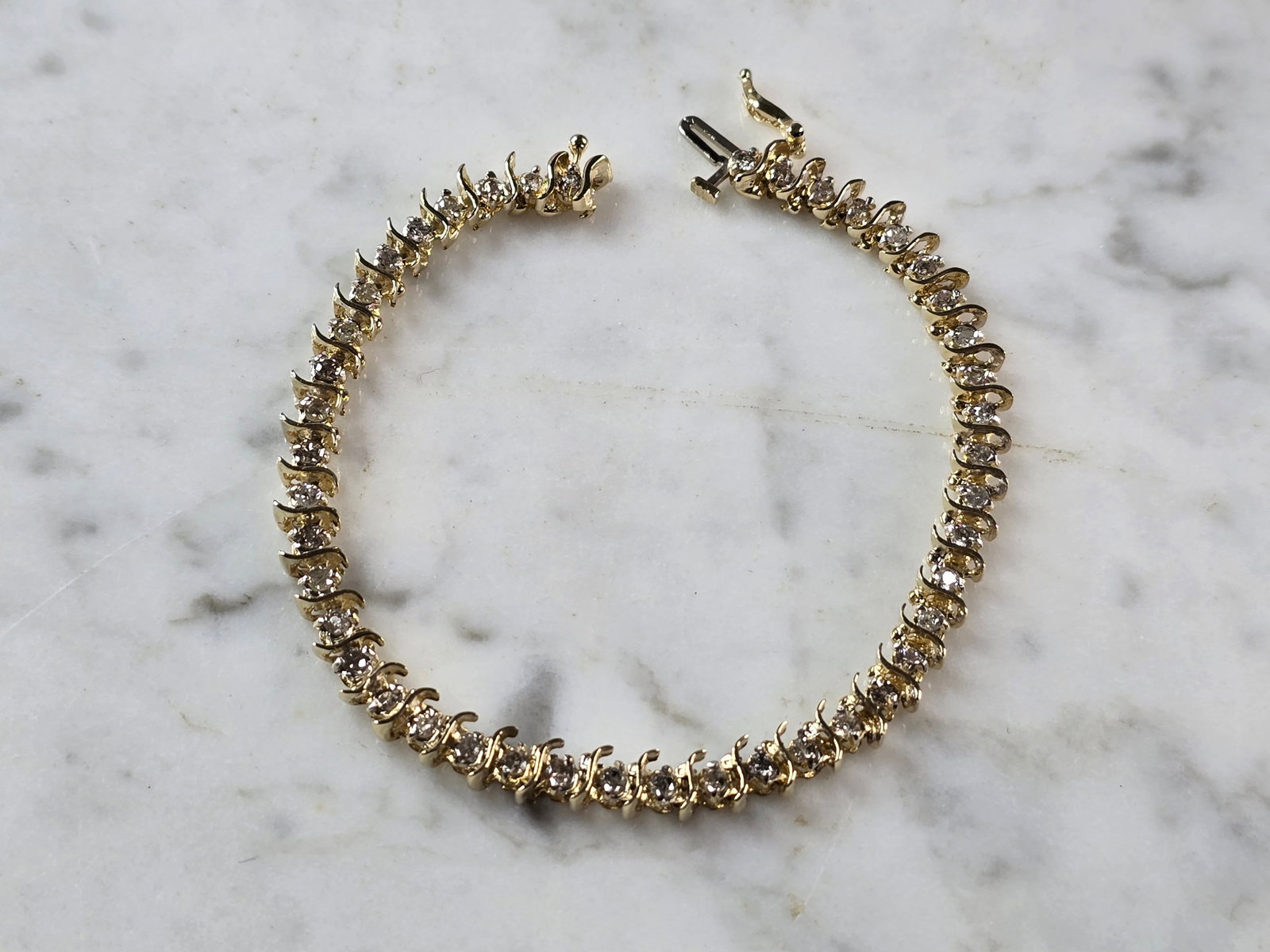 Womens Vintage Estate 14K Yellow Gold Diamond Tennis Bracelet: A WOMENS VINTAGE ESTATE 14K YELLOW GOLD DIAMOND TENNIS BRACELET. THE BRACELET MEASURES 7 3/8" LONG BY 3/16" WIDE, AND WEIGHS 11.4g. THERE ARE 44 DIAMONDS, EACH ABOUT .05cts. WOULD MAKE A GREAT GIFT FO