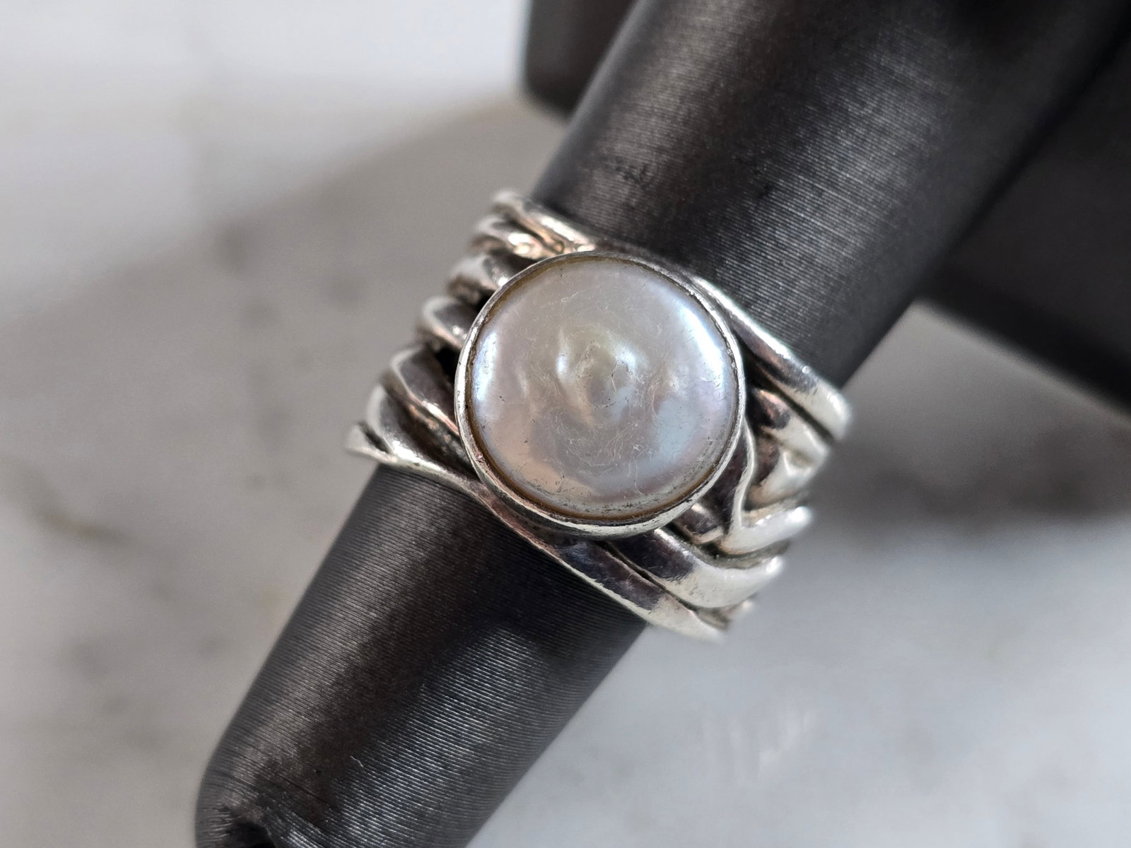 Womens Vintage Estate Sterling Silver Modernist Ring: A WOMENS VINTAGE ESTATE STERLING SILVER MODERNIST RING. STONE APPEARS TO BE MOTHER OF PEARL. THE RING SIZE IS A 7.0, AND WEIGHS 10.2g. THE WIDTH OF THE RING IS 1/2". ANY QUESTIONS PLEASE DO NOT HESITA