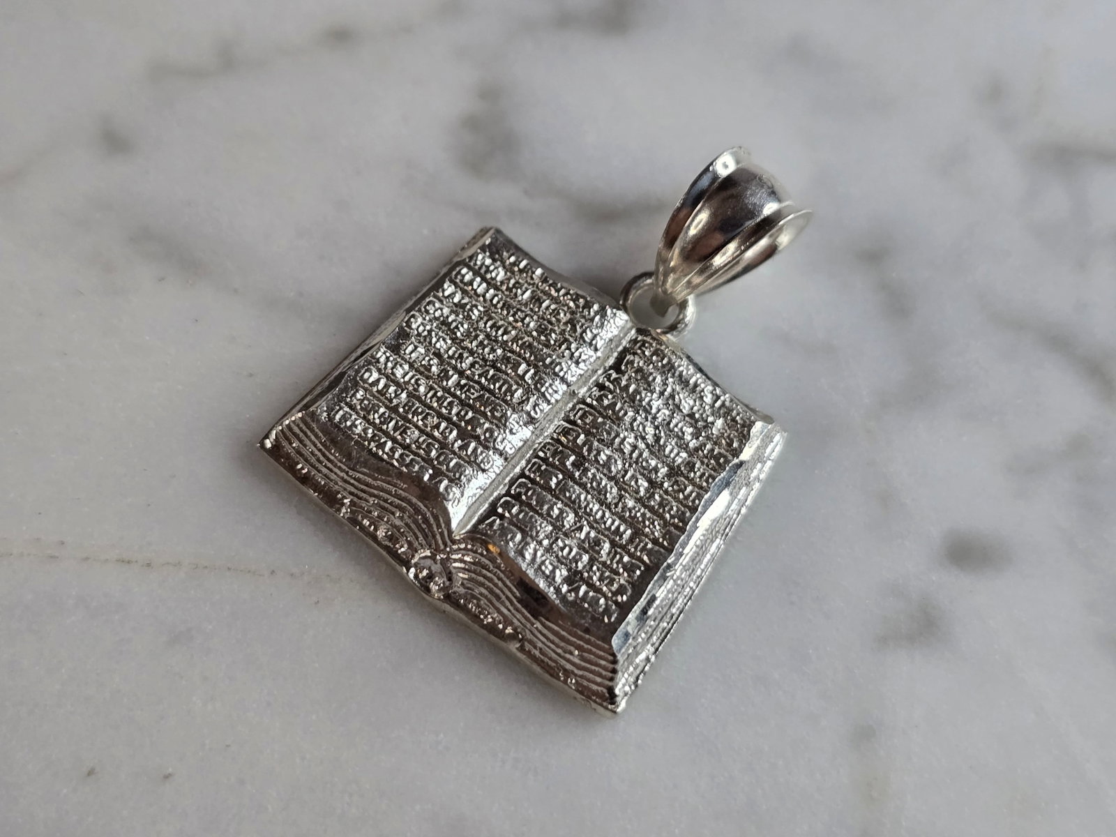 Sterling Silver Religious Holy Bible Pendant: A STERLING SILVER RELIGIOUS HOLY BIBLE PENDANT. PENDANT WEIGHS 2.7g, AND MEASURES 1" LONG BY 7/8" WIDE. MAKES A GREAT GIFT FOR THAT SOMEONE SPECIAL. ANY QUESTIONS, PLEASE ASK. BE SURE TO CHECK OUT OUR