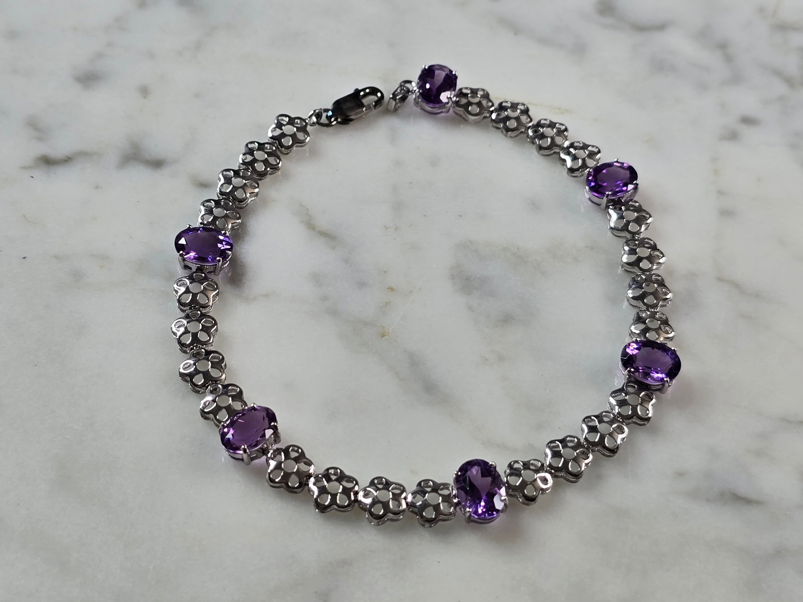 Womens Vintage Estate Sterling Silver Amethyst Bracelet: A WOMENS VINTAGE ESTATE STERLING SILVER AMETHYST BRACELET. BRACELET MEASURES 8 1/8" LONG BY 1/4" WIDE, AND WEIGHS 6.1g. NOT SURE IF STONES ARE NATURAL OR MAN MADE. THIS WOULD MAKE A LOVELY GIFT FOR TH
