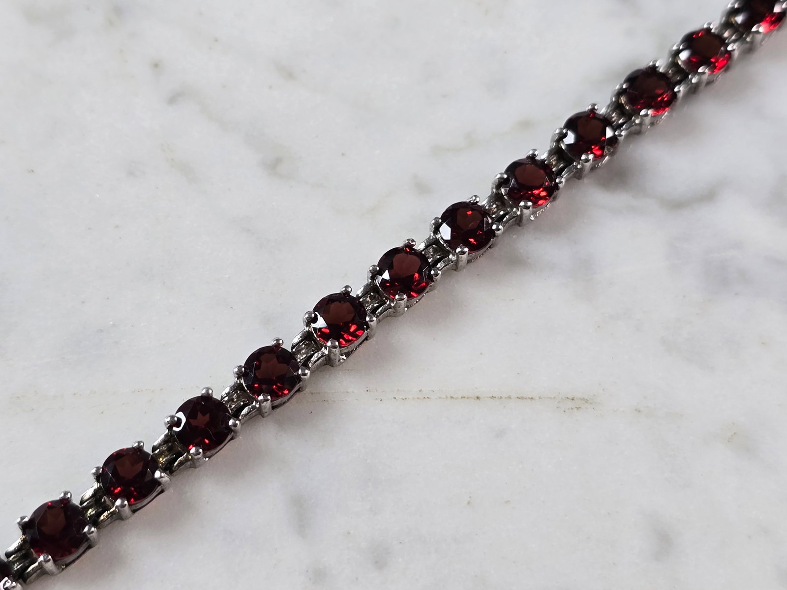 Womens Vintage Estate Sterling Silver Garnet Bracelet: A WOMENS VINTAGE ESTATE STERLING SILVER GARNET BRACELET. BRACELET MEASURES 7" LONG AND 1/4" WIDE, AND WEIGHS 13.6g. NOT SURE IF STONES ARE NATURAL OR MAN MADE. WOULD MAKE A LOVELY GIFT FOR THAT SOMEON