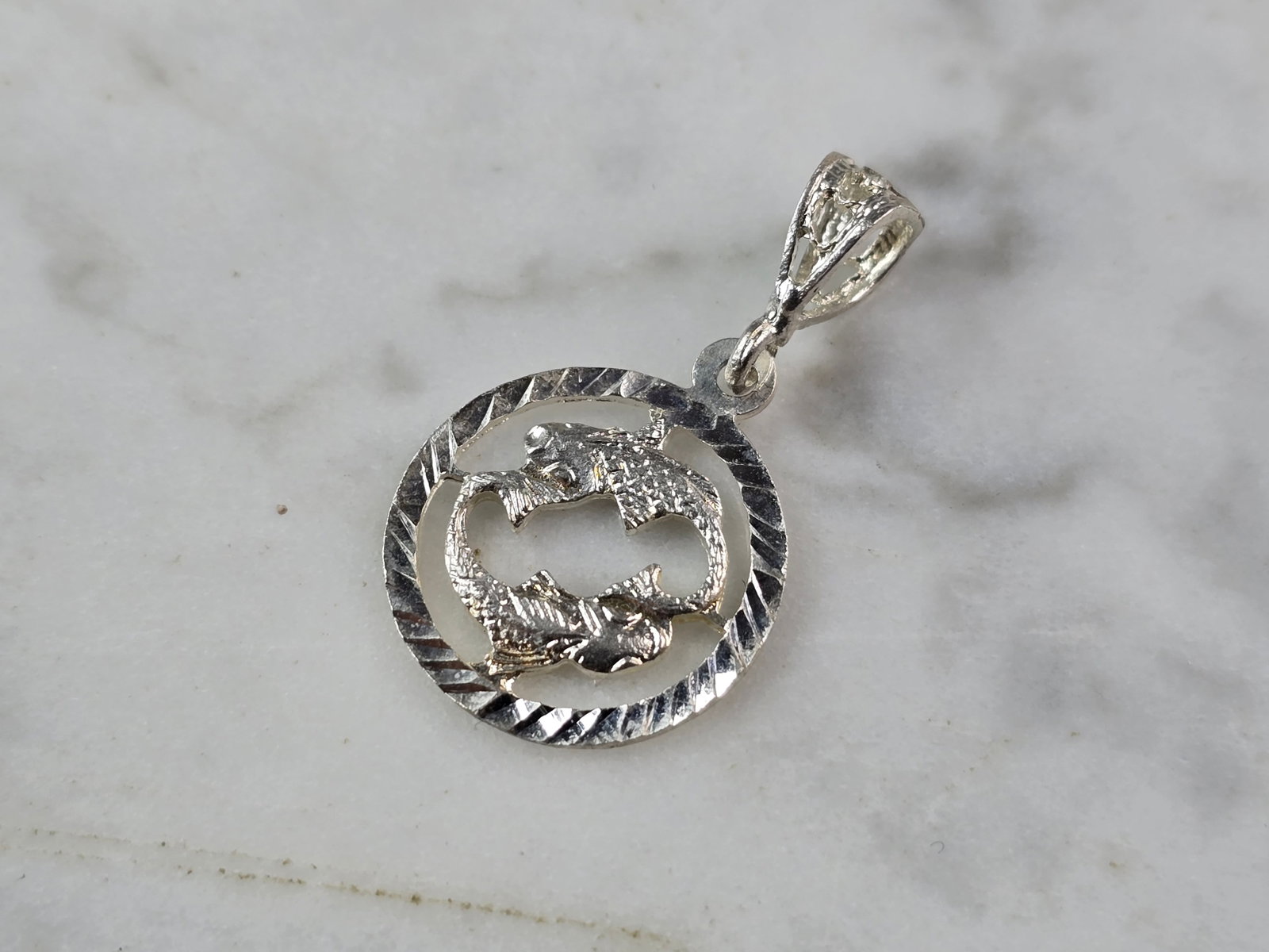 Womens Vintage Estate Sterling Silver Zodiac Pisces Pendant: A WOMENS VINTAGE ESTATE STERLING SILVER ZODIAC PISCES PENDANT. THE PENDANT WEIGHS 1.2g AND MEASURES 1 1/8" LONG BY 5/8" WIDE. PENDANT IS NOT MARKED, BUT IT HAS BEEN TESTED AND IS GUARANTEED TO BE AS D