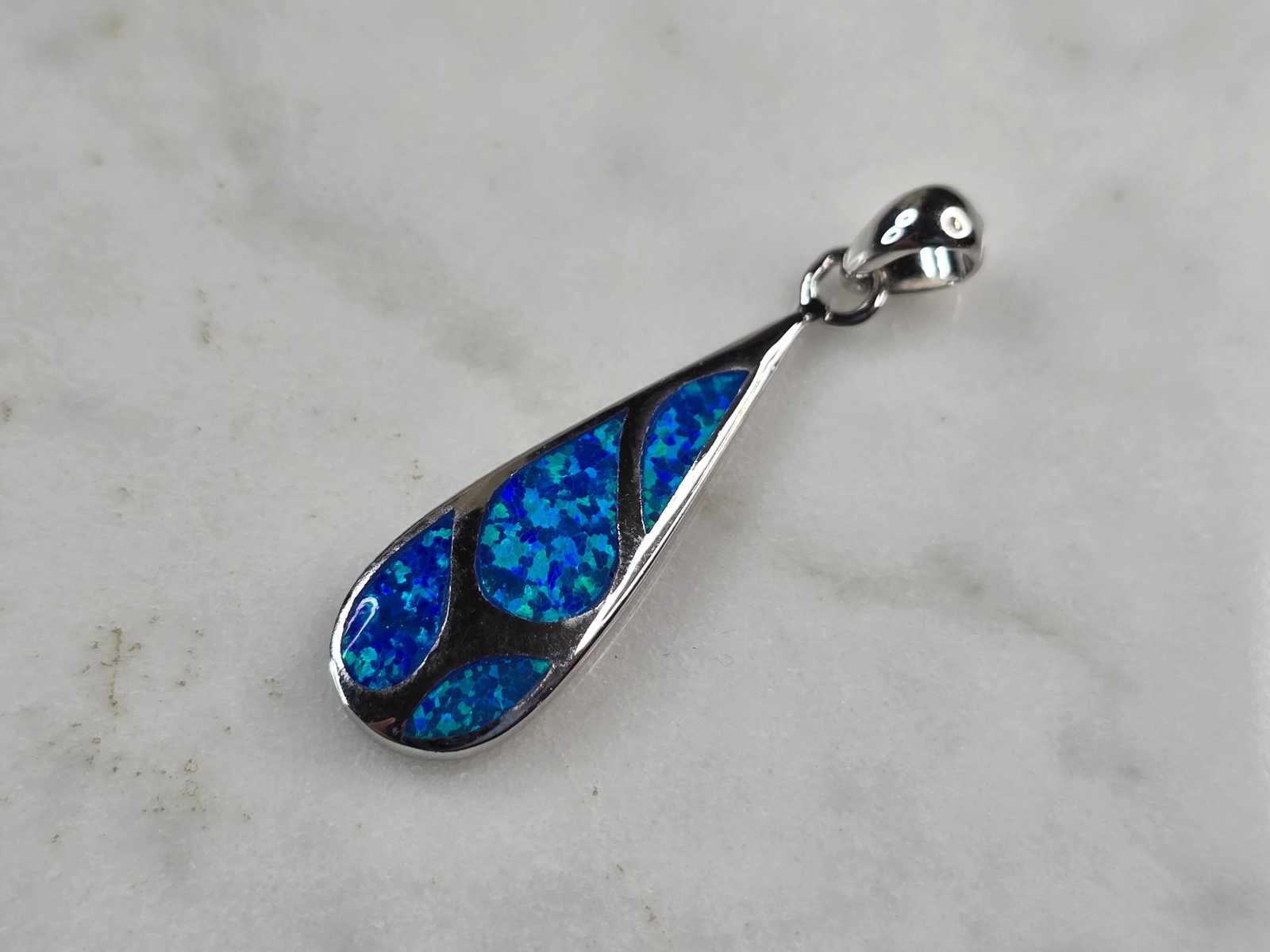 Womens Sterling Silver Blue Opal Modernist Pendant: A WOMENS ESTATE STERLING SILVER BLUE OPAL MODERNIST PENDANT. NOT SURE IF STONES ARE REAL OR MAN MADE. THE PENDANT WEIGHS 2.9g AND MEASURES 1 1/4" LONG BY 3/8" WIDE. MAKES A GREAT GIFT FOR THAT SOMEONE