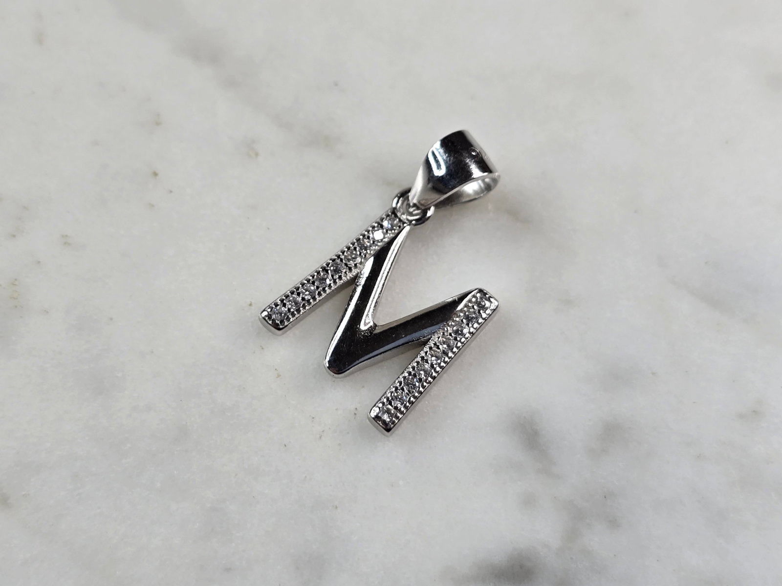 Womens Vintage Estate Sterling Silver CZ Letter "M" Pendant: FOR SALE IS THIS WOMENS VINTAGE ESTATE STERLING SILVER CZ LETTER "M" PENDANT. PENDANT WEIGHS 1.5g AND PENDANT MEASURES 3/4" LONG BY 1/2" WIDE. MAKES A GREAT GIFT FOR THAT SOMEONE SPECIAL. IF ANY QUEST