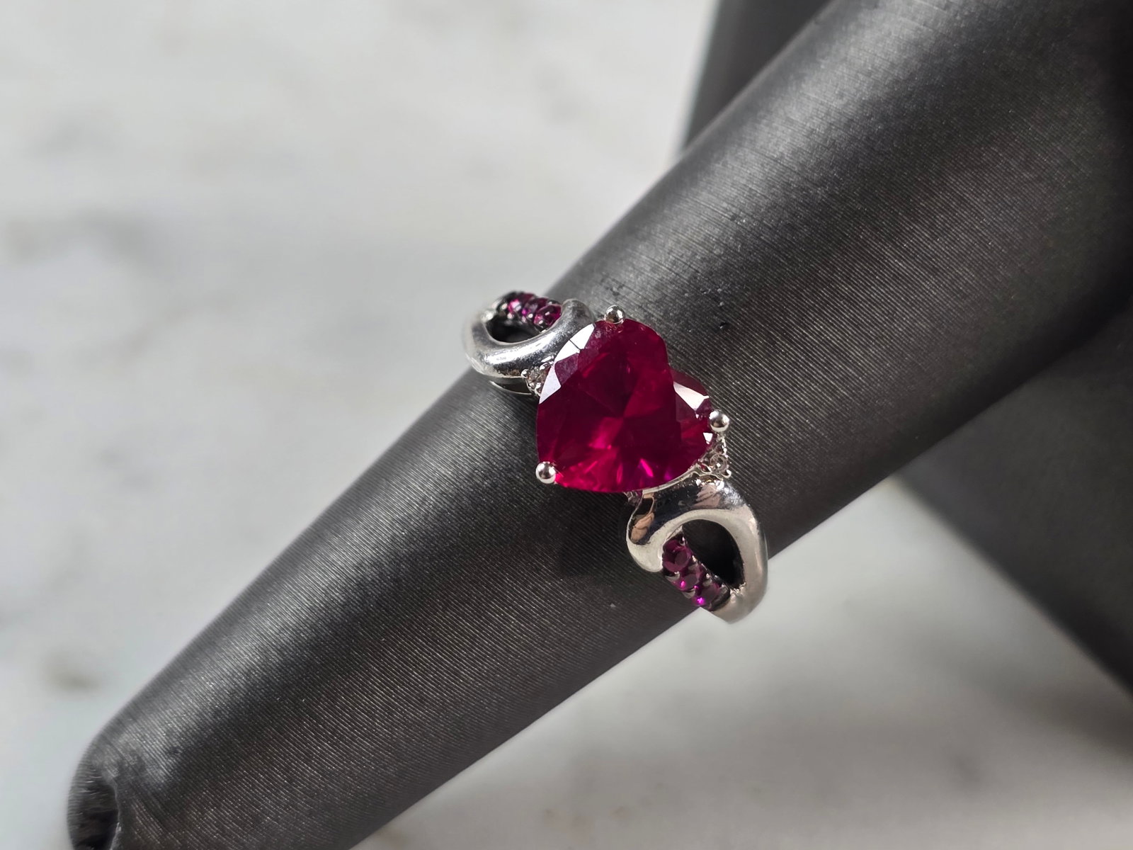 Womens Vintage Estate Sterling Silver Ruby Heart Ring: A WOMENS VINTAGE ESTATE STERLING SILVER RUBY COLORED HEART RING. THE RING SIZE IS A 7.0, AND WEIGHS 3.1g. THE WIDTH OF THE RING IS 3/8". STONE IS SYNTHETIC. THIS WOULD MAKE A NICE GIFT FOR THAT SOMEON