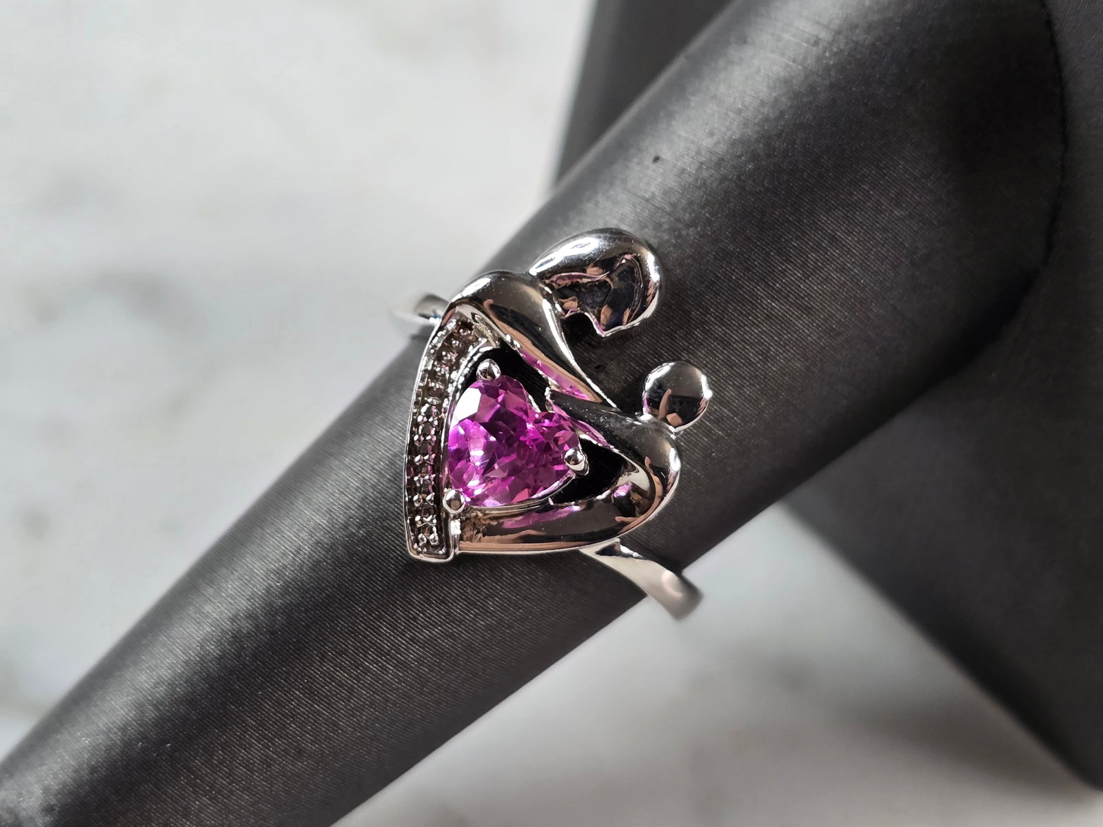 Womens Vintage Estate Sterling Silver Mother Child Heart Ring: A WOMENS VINTAGE ESTATE STERLING SILVER MOTHER AND CHILD HEART RING, WITH A ROSE QUARTZ COLORED STONE. THE RING SIZE IS A 8.0, AND WEIGHS 3.9g. THE WIDTH OF THE RING IS 3/4". STONE IS SYNTHETIC. THIS 