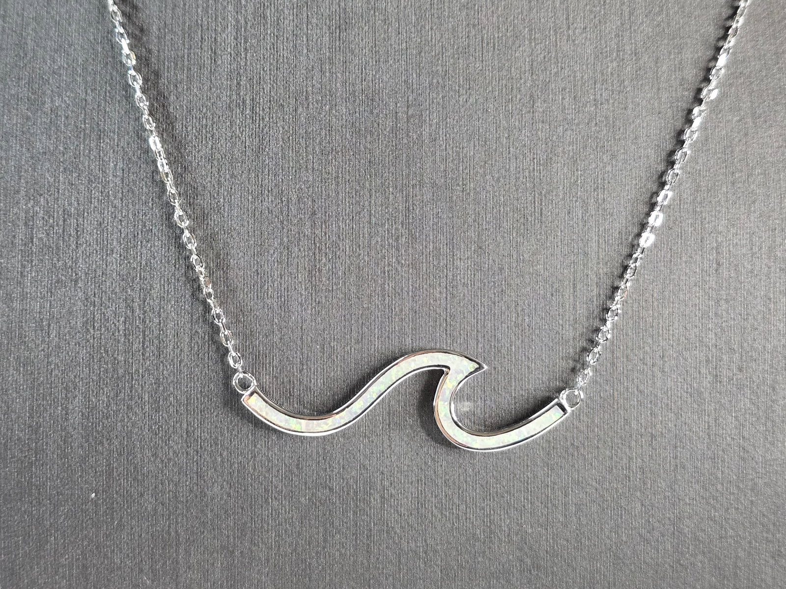 Womens Sterling Silver Opal Tsunami Wave Pendant Necklace: A WOMENS STERLING SILVER OPAL TSUNAMI WAVE PENDANT. THE PENDANT WITH NECKLACE WEIGHS 4.0g. THE PENDANT MEASURES 1 5/8" LONG BY 1/2" WIDE, AND THE NECKLACE MEASURES 18" LONG. NOT SURE IF STONES ARE NAT