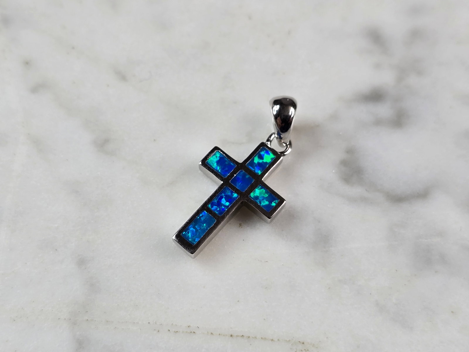 Womens Sterling Silver Blue Opal Religious Cross Pendant: A WOMENS STERLING SILVER BLUE OPAL RELIGIOUS CROSS PENDANT. NOT SURE IF STONES ARE REAL OR MAN MADE. THE PENDANT WEIGHS 1.8g AND MEASURES 7/8" LONG BY 1/2" WIDE. MAKES A GREAT GIFT FOR THAT SOMEONE SP