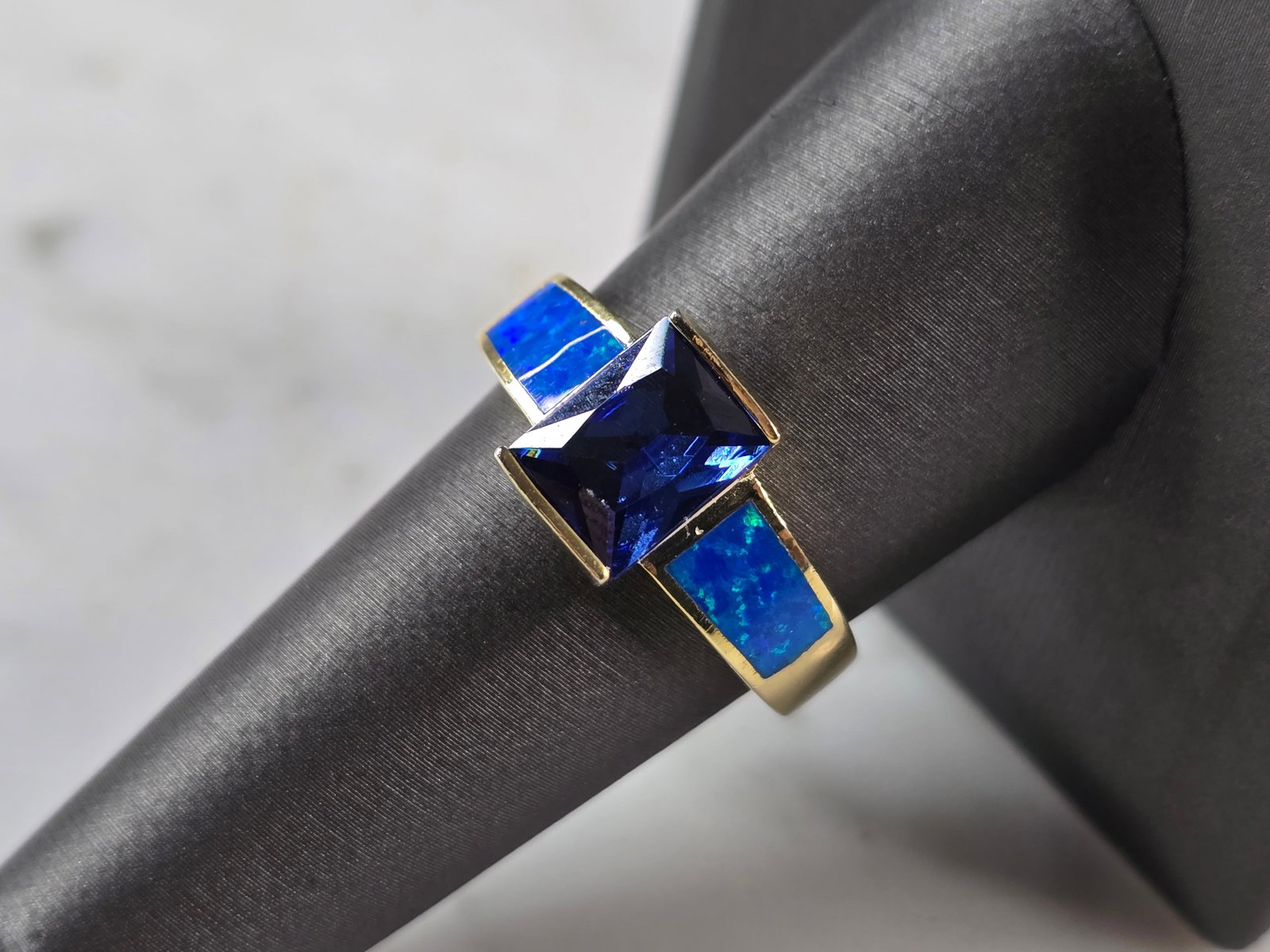 Womens Sterling Silver Gold Tone Blue Opal Tanzanite Ring: A WOMENS STERLING SILVER GOLD ONE BLUE OPAL & TANZANITE COLORED RING. THE RING IS A SIZE 9.0, AND WEIGHS 5.6g. WIDTH OF RING MEASURES 3/8". NOT SURE IF STONE IS NATURAL OR MAN MADE. THE RING MAKES A B