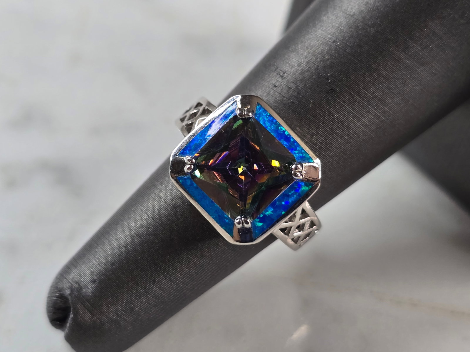 Womens Sterling Silver Modernist Blue Opal Mystic Topaz Ring: A WOMENS STERLING SILVER MODERNIST BLUE OPAL & MYSTIC TOPAZ COLORED RING. THE RING IS A SIZE 6.0, AND WEIGHS 6.3g. WIDTH OF RING MEASURES 1/2". NOT SURE IF STONE IS NATURAL OR MAN MADE. THE RING MAKES