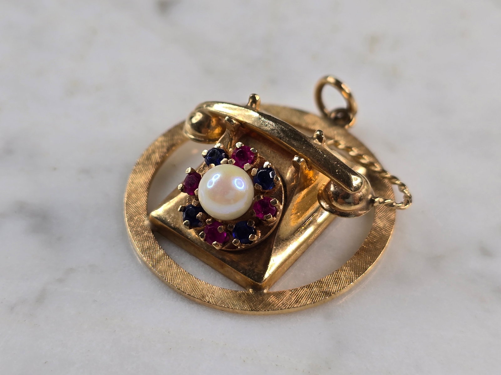 Womens Vintage Estate 14K Yellow Gold Telephone Pendant: A WOMENS VINTAGE ESTATE 14K YELLOW GOLD RUBIES AND SAPPHIRE TELEPHONE PENDANT. NOT SURE IF THE STONES ARE NATURAL OR MAN MADE. THE PENDANT MEASURES 1 1/2" LONG BY 1 1/4" WIDE, AND WEIGHS 12.2g. WOULD 