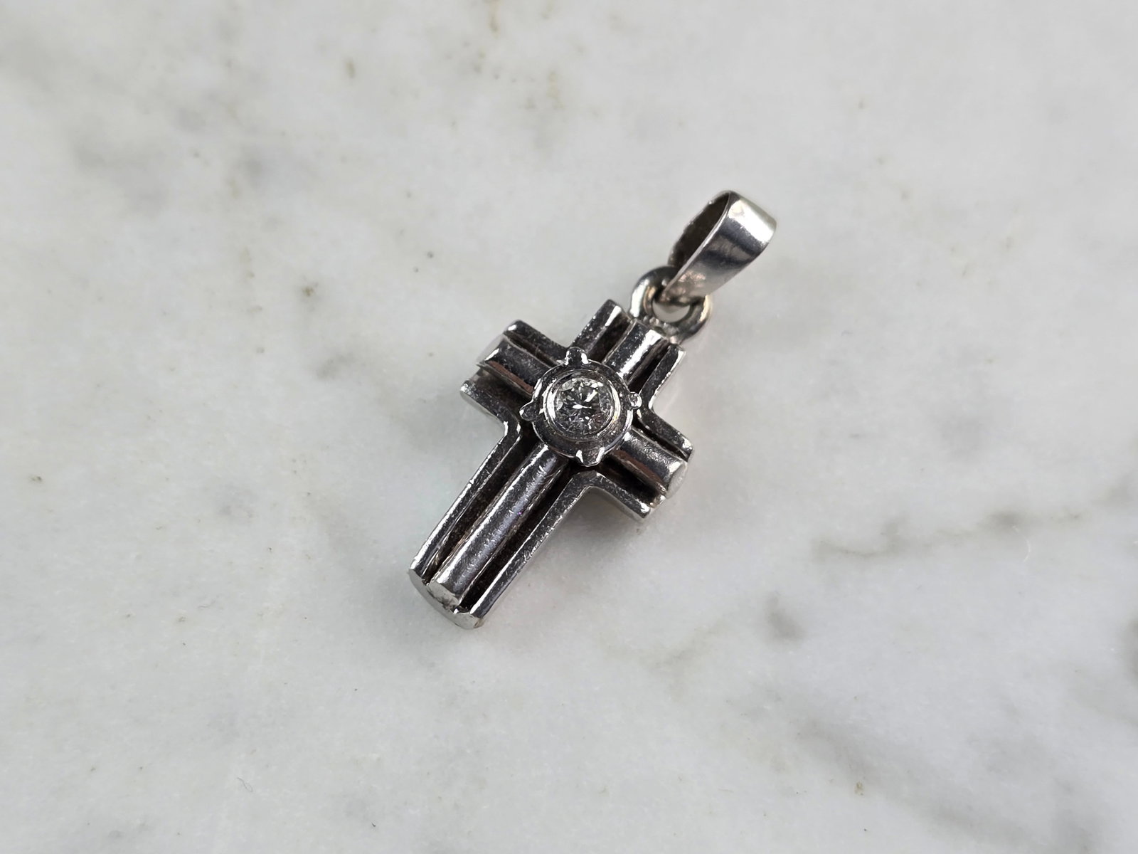 Womens Vintage 14K White Gold Diamond Cross Pendant: A VINTAGE ESTATE 14K WHITE GOLD DIAMOND CROSS PENDANT. THE PENDANT MEASURES 1" BY 1/2", AND WEIGHS 4.2g. THE DIAMOND IS ABOUT .10cts. PENDANT IS NOT MARKED BUT IT HAS BEEN TESTED AND IS GUARANTEED TO 