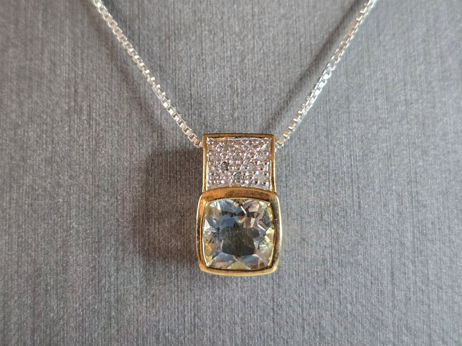 Womens Sterling Silver Necklace W/ Topaz ? Stone Pendant: A WOMENS VINTAGE ESTATE STERLING SILVER NECKLACE WITH A TOPAZ COLORED STONE PENDANT. NOT SURE IF THE STONE IS NATURAL OR MAN MADE. THE PENDANT MEASURES 3/4" BY 3/8". THE NECKLACE MEASURES 18" LONG. TO