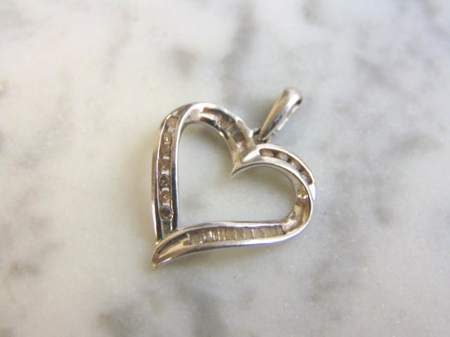 Womens 10K Gold Diamond Heart Pendant: A WOMENS VINTAGE ESTATE 10K WHITE GOLD HEART PENDANT WITH DIAMONDS. PENDANT WEIGHS 1.7g, AND MEASURES 1" BY 5/8". THERE ARE ABOUT .27cts OF DIAMONDS IN THIS PENDANT. WOULD MAKE A LOVELY GIFT FOR THAT 