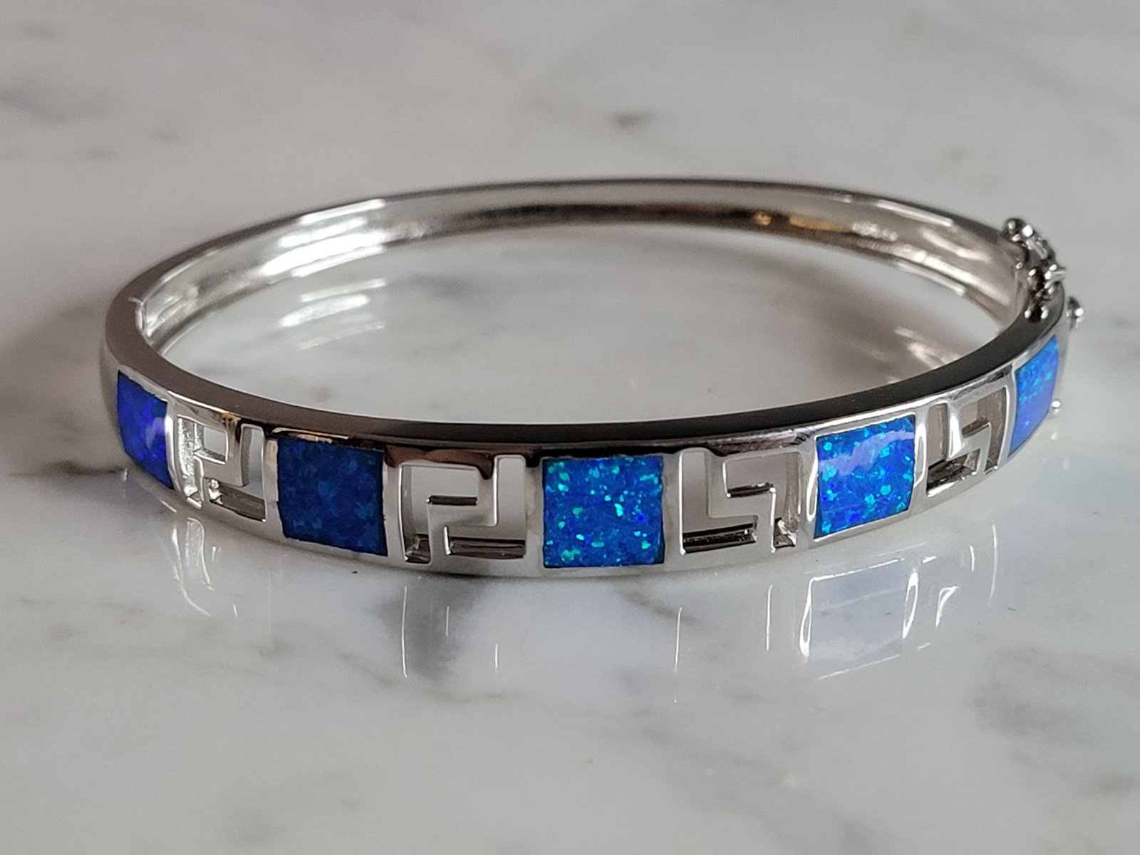 Womens Sterling Silver Modernist Blue Opal Bangle Bracelet: A WOMENS STERLING SILVER MODERNIST BLUE OPAL COLORED BANGLE BRACELET WITH A GREEK KEY DESIGN. THE BRACELET WEIGHS 17.4g AND IS ABOUT 3/8" WIDE. THE CIRCUMFERENCE IS 6 3/4". NOT SURE IF OPAL IS NATURAL