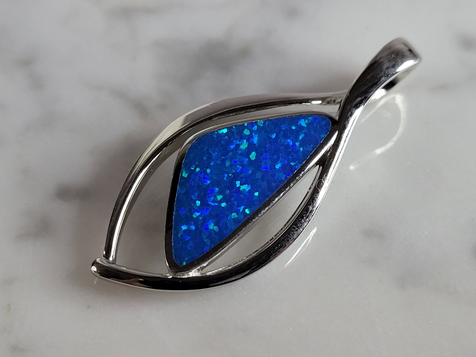 Womens Sterling Silver Blue Opal Modernist Pendant: A WOMENS STERLING SILVER BLUE OPAL MODERNIST PENDANT. NOT SURE IF STONES ARE REAL OR MAN MADE. THE PENDANT WEIGHS 4.5g AND MEASURES 1 3/8" LONG BY 1/2" WIDE. MAKES A GREAT GIFT FOR THAT SOMEONE SPECIA