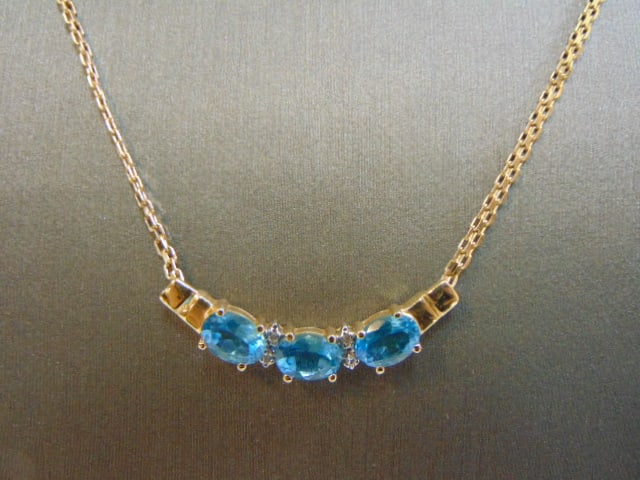 Womens 14k Gold Necklace Topaz & Diamond Pendant: A WOMENS VINTAGE ESTATE 14K GOLD NECKLACE WITH A TOPAZ COLORED PENDANT ACCENTED WITH TINY DIAMOND CHIPS. THE NECKLACE MEASURES 17" LONG, AND WEIGHS 6.4g. NOT SURE IF THE TOPAZ STONES ARE REAL OR MAN M