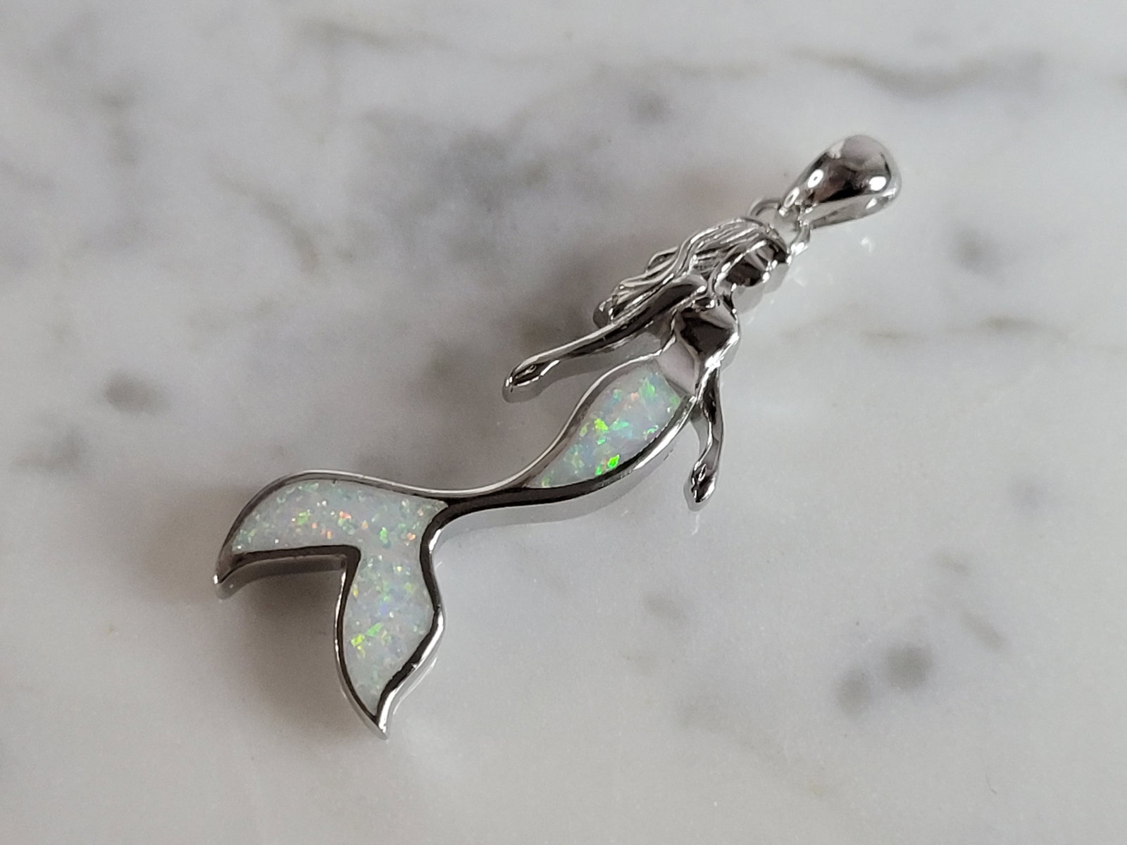 Womens Sterling Silver Modernist Opal Mermaid Pendant: WOMENS STERLING SILVER MODERNIST OPAL COLORED MERMAID PENDANT THAT WEIGHES 4.3g, AND MEASURES 1 3/8" LONG BY 1/2" WIDE. NOT SURE IF STONES ARE REAL OR MAN MADE. ANY QUESTIONS, PLEASE DO NOT HESITATE T