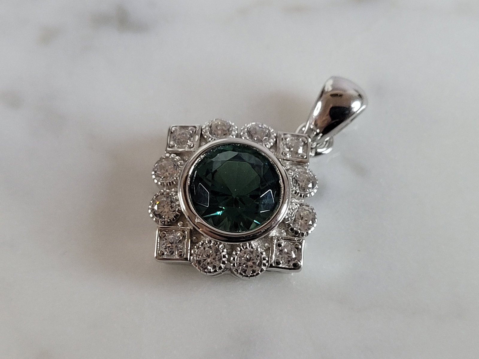 Womens Estate Sterling Silver Modernist CZ Pendant: A WOMENS ESTATE STERLING SILVER MODERNIST CZ PENDANT WITH AN EMERALD COLORED STONE. PENDANT WEIGHS 2.7g AND MEASURES 7/8" LONG BY 5/8" WIDE. MAKES A GREAT GIFT FOR THAT SOMEONE SPECIAL. ANY QUESTIONS,