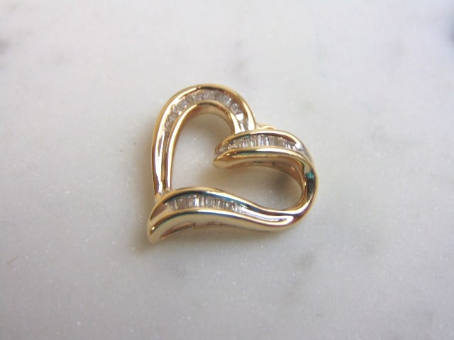 Womens Vintage Estate 10K Gold Diamond Heart Pendant: A WOMENS VINTAGE ESTATE 10K GOLD HEART DIAMOND PENDANT . PENDANT WEIGHS 3.2g, AND MEASURES 3/4" BY 3/4". THERE ARE ABOUT .28cts OF DIAMONDS IN THIS PENDANT. PENDANT DOES NEED A NEW BAIL. WOULD MAKE A 