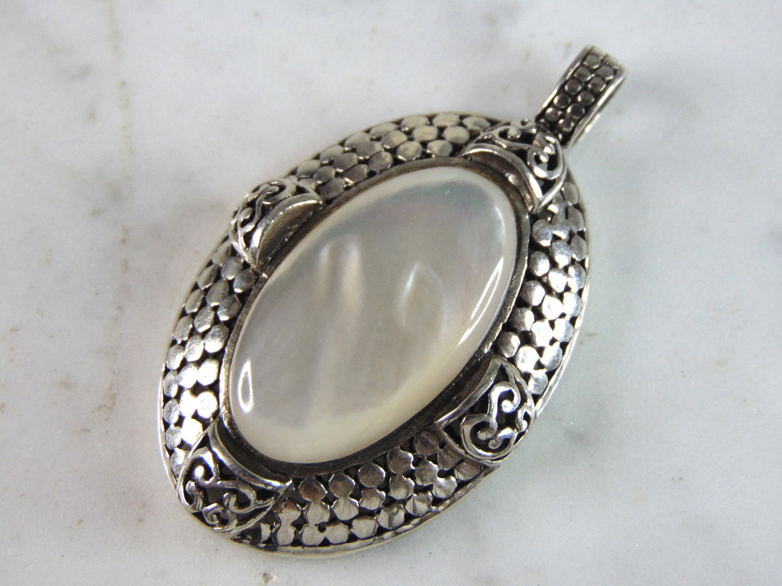 Womens Vintage Estate Sterling Silver M.O.P. Pendant: A WOMENS VINTAGE ESTATE STERLING SILVER MOTHER OF PERAL PENDANT. NOT SURE IF STONE IS NATURAL OR MAN MADE. PENDANT WEIGHS 10.2g AND PENDANT MEASURES 1 7/8" LONG BY 1 1/8" WIDE. MAKES A GREAT GIFT FOR 