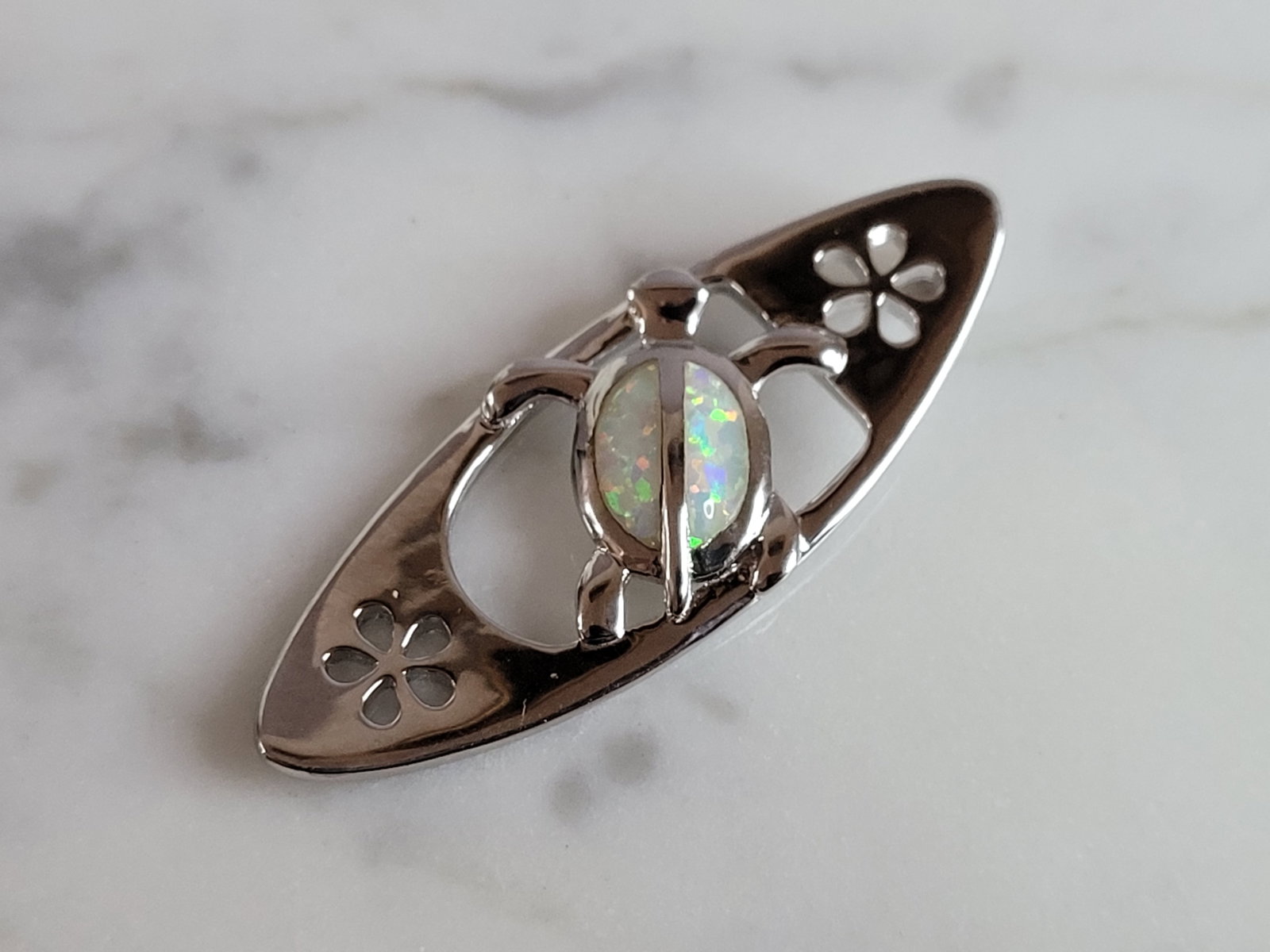 Womens Sterling Silver Opal Surfing Sea Turtle Pendant: A WOMENS STERLING SILVER OPAL SURFING SEA TURTLE. NOT SURE IF STONES ARE REAL OR MAN MADE. THE PENDANT WEIGHS 4.1g AND MEASURES 1 1/2" LONG BY 1/2" WIDE. MAKES A GREAT GIFT FOR THAT SOMEONE SPECIAL. A