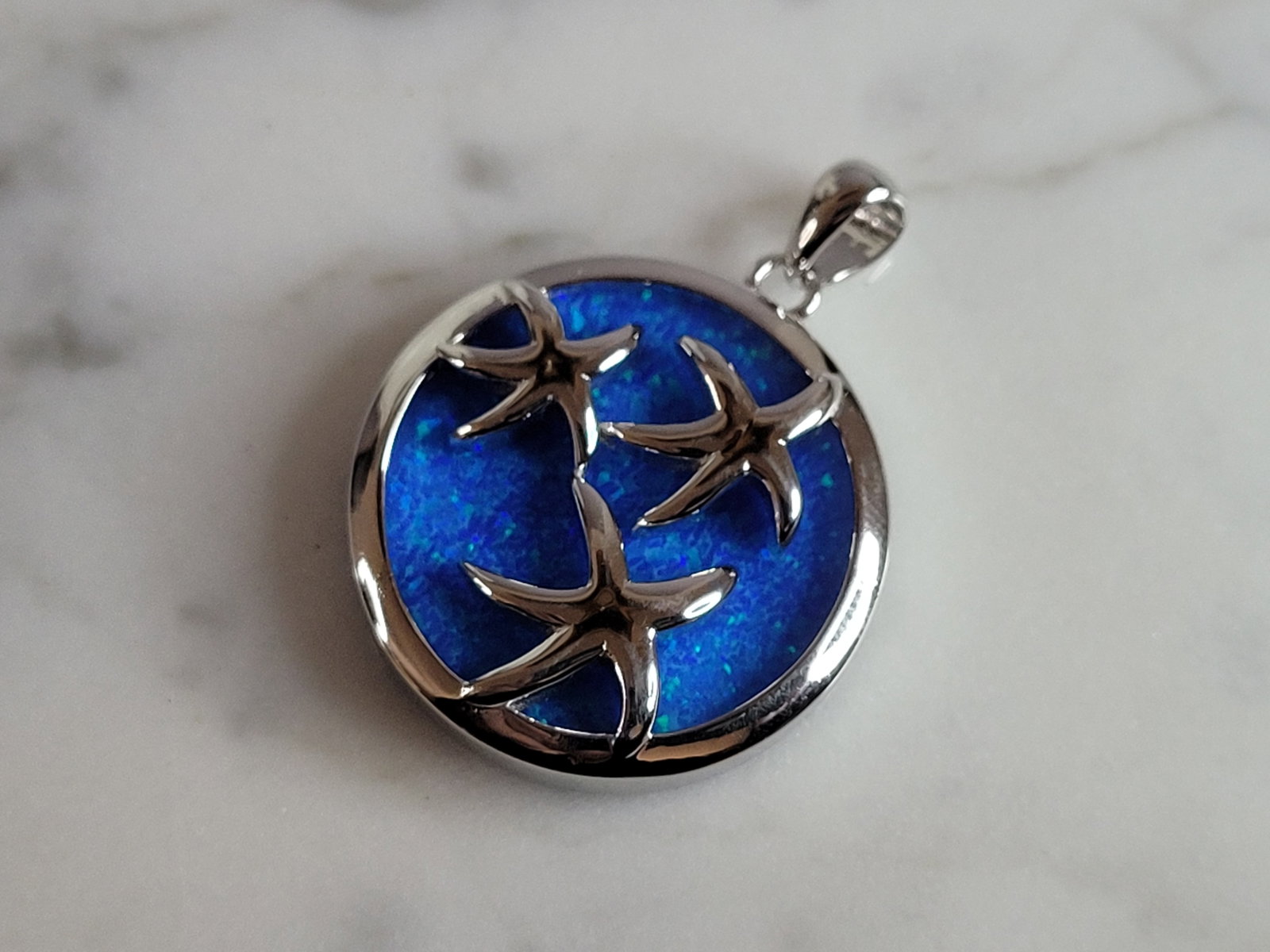 Womens Sterling Silver Blue Opal Star Fish Pendant: A WOMENS STERLING SILVER BLUE OPAL STAR FISH PENDANT. NOT SURE IF STONES ARE REAL OR MAN MADE. THE PENDANT WEIGHS 6.1g AND MEASURES 1 1/4" LONG BY 7/8" WIDE. MAKES A GREAT GIFT FOR THAT SOMEONE SPECIA