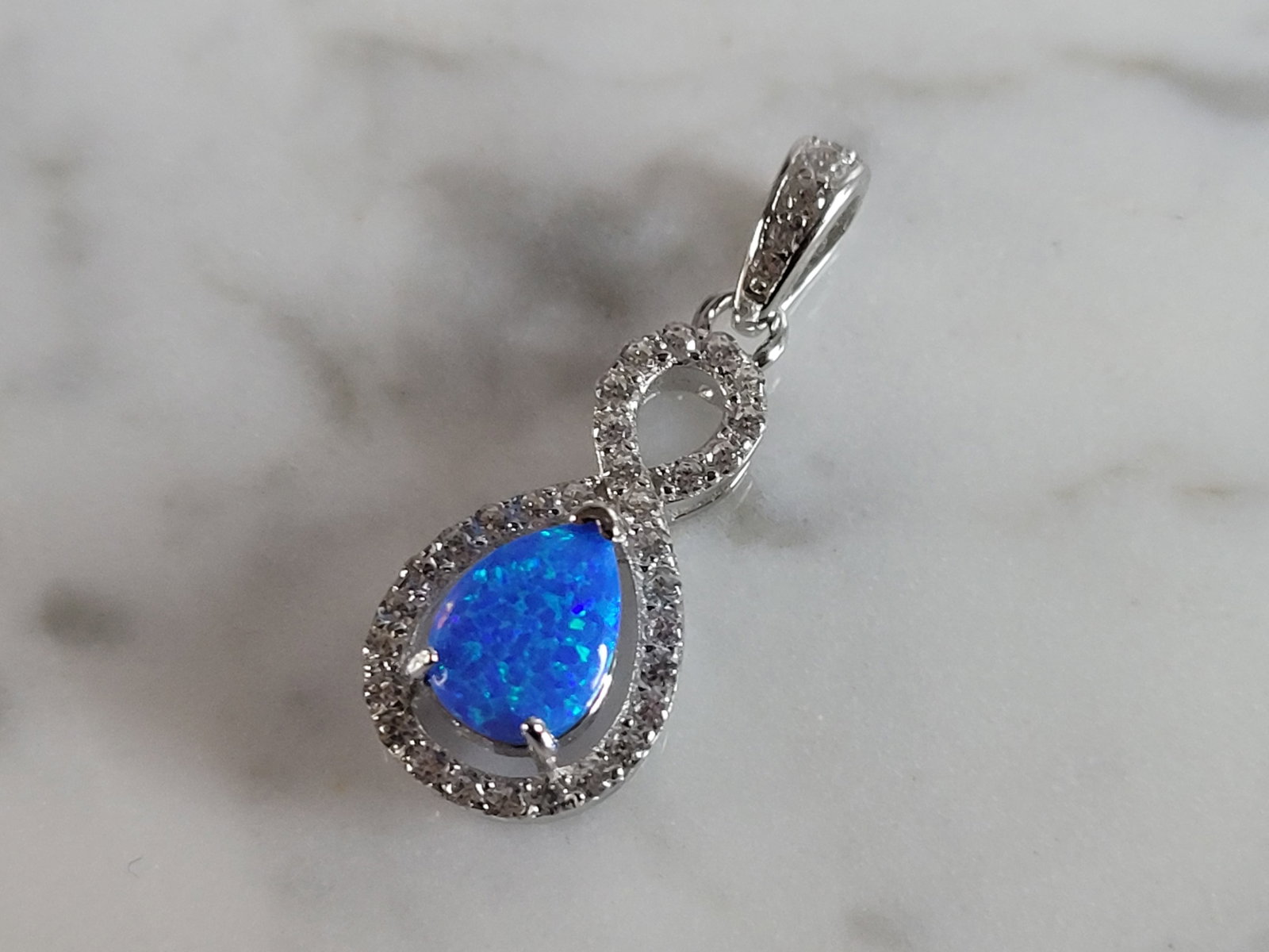 Womens Sterling Silver Blue Opal Modernist Pendant: A WOMENS STERLING SILVER BLUE OPAL MODERNIST PENDANT. NOT SURE IF STONES ARE REAL OR MAN MADE. THE PENDANT WEIGHS 1.2g AND MEASURES 7/8" LONG BY 3/8" WIDE. MAKES A GREAT GIFT FOR THAT SOMEONE SPECIAL.