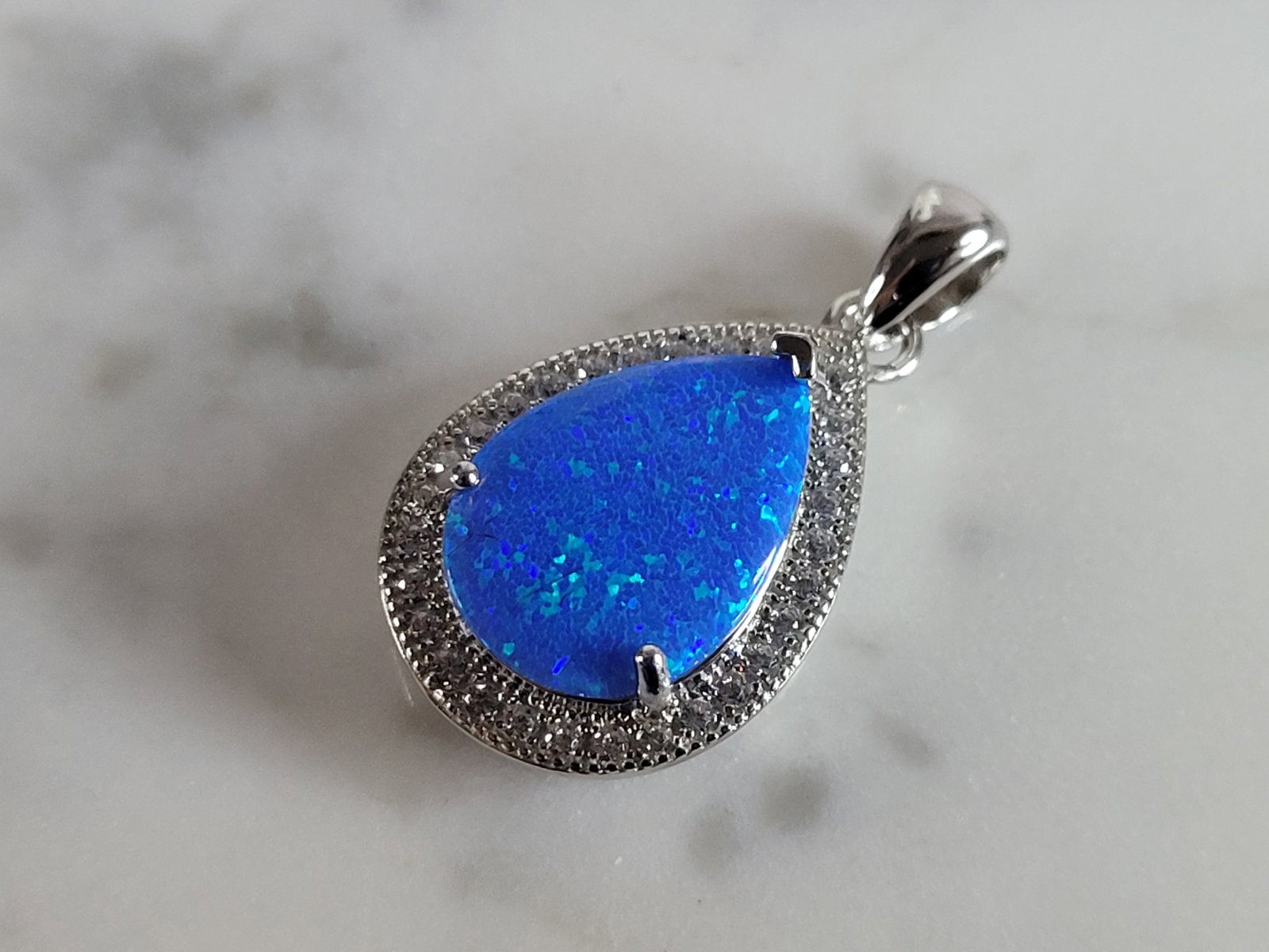 Womens Sterling Silver Blue Opal Modernist Pendant: A WOMENS STERLING SILVER BLUE OPAL MODERNIST PENDANT. NOT SURE IF STONES ARE REAL OR MAN MADE. THE PENDANT WEIGHS 2.6g AND MEASURES 1" LONG BY 1/2" WIDE. MAKES A GREAT GIFT FOR THAT SOMEONE SPECIAL. A
