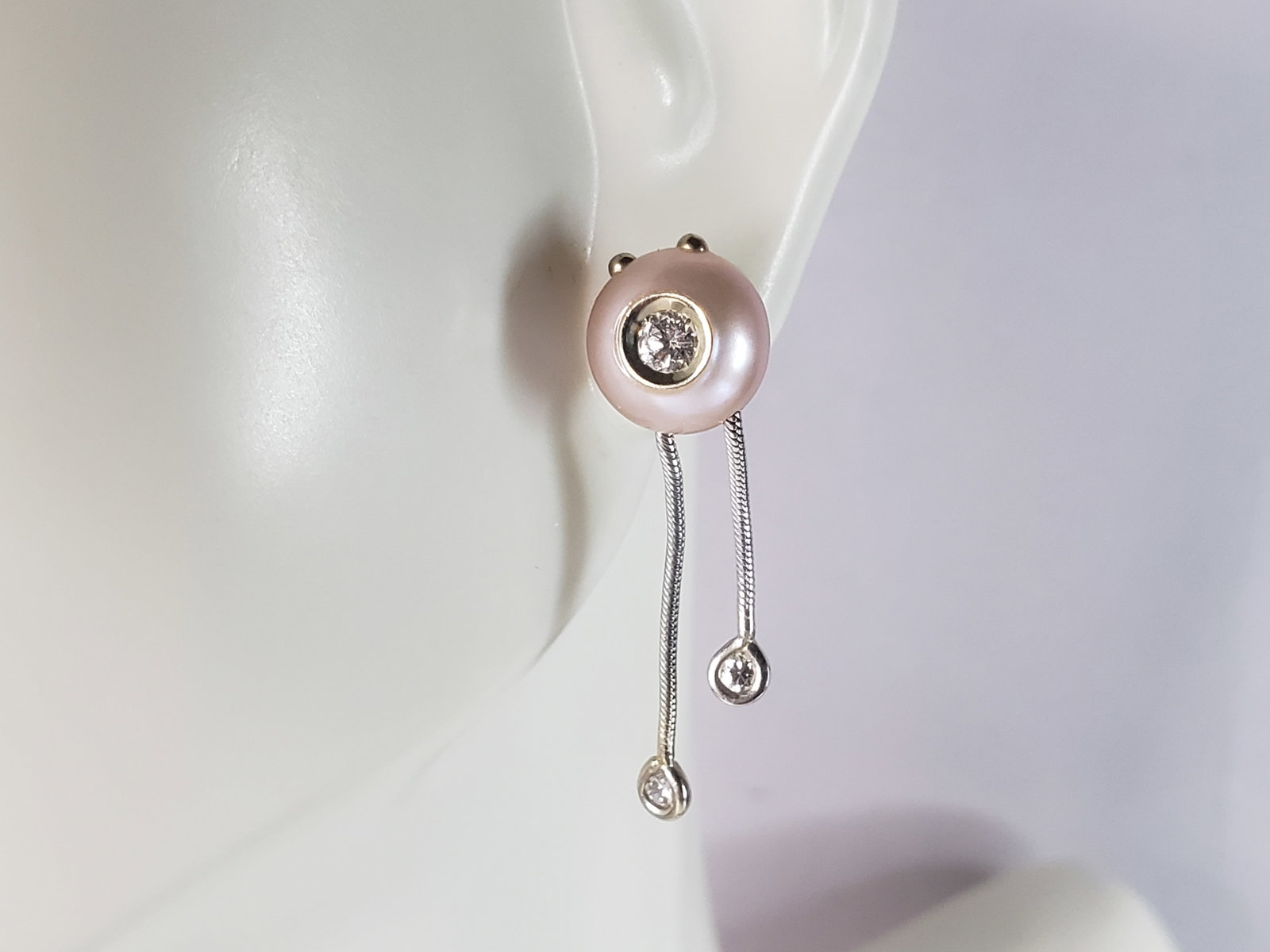 Womens Vintage Estate 14K White Gold Earrings W/ Diamonds & Pearls: A PAIR OF WOMENS VINTAGE ESTATE 14K WHITE GOLD DIAMOND AND PEARL EARRINGS. NOT SURE IF THE PEARLS ARE REAL OR NOT. THEY DO HAVE A GRITTY FEELING TO THE TEETH. THE EARRINGS WEIGH 3.4g, AND MEASURE 1" L