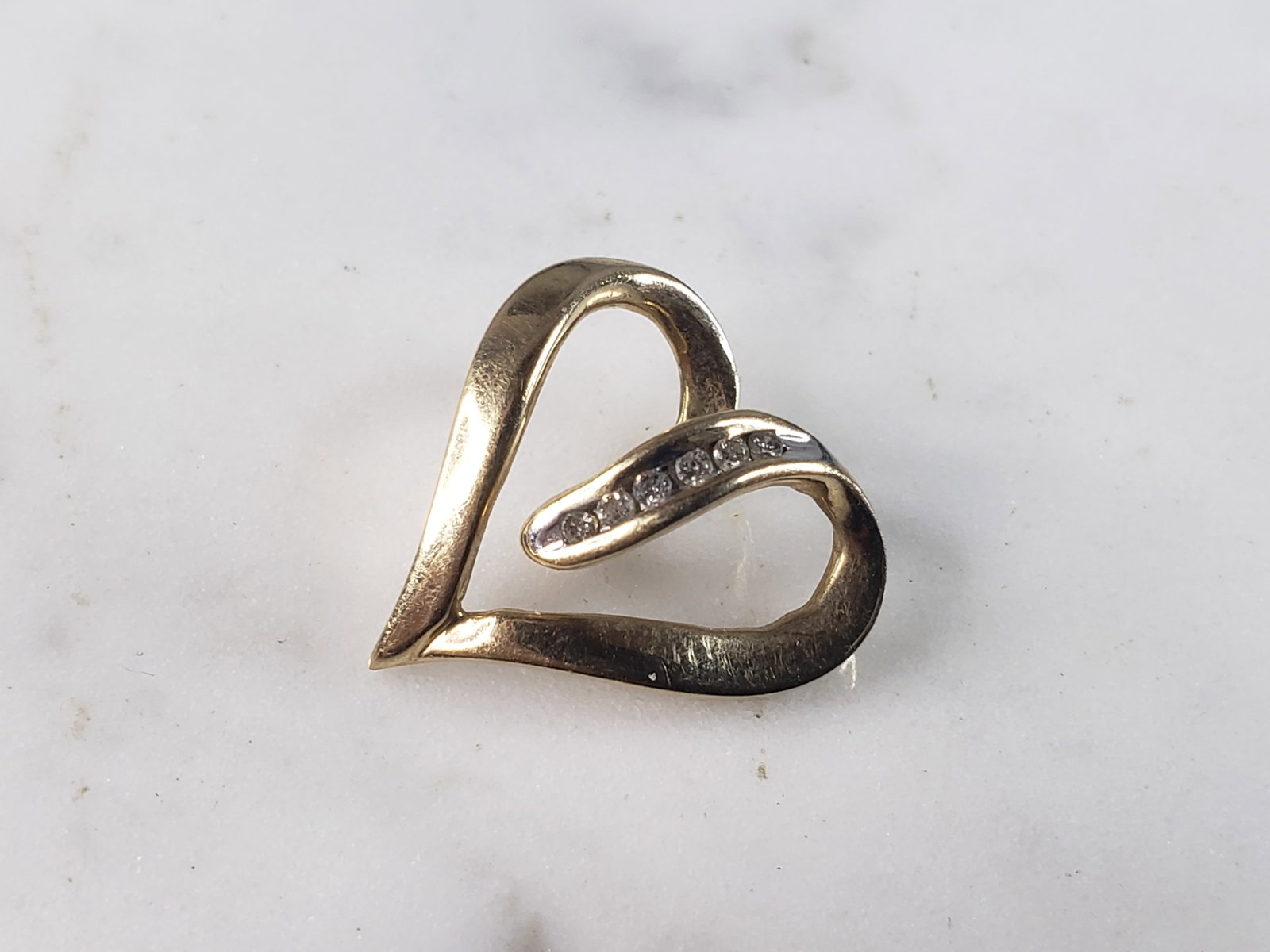 Womens Vintage Estate 10K Gold Heart Diamond Pendant: A WOMENS VINTAGE ESTATE 10K YELLOW GOLD HEART PENDANT WITH DIAMONDS. PENDANT WEIGHS 2.2g, AND MEASURES 3/4" BY 5/8". PENDANT HAS ABOUT .12cts IN IT. WOULD MAKE A LOVELY GIFT FOR THAT SOMEONE SPECIAL. 