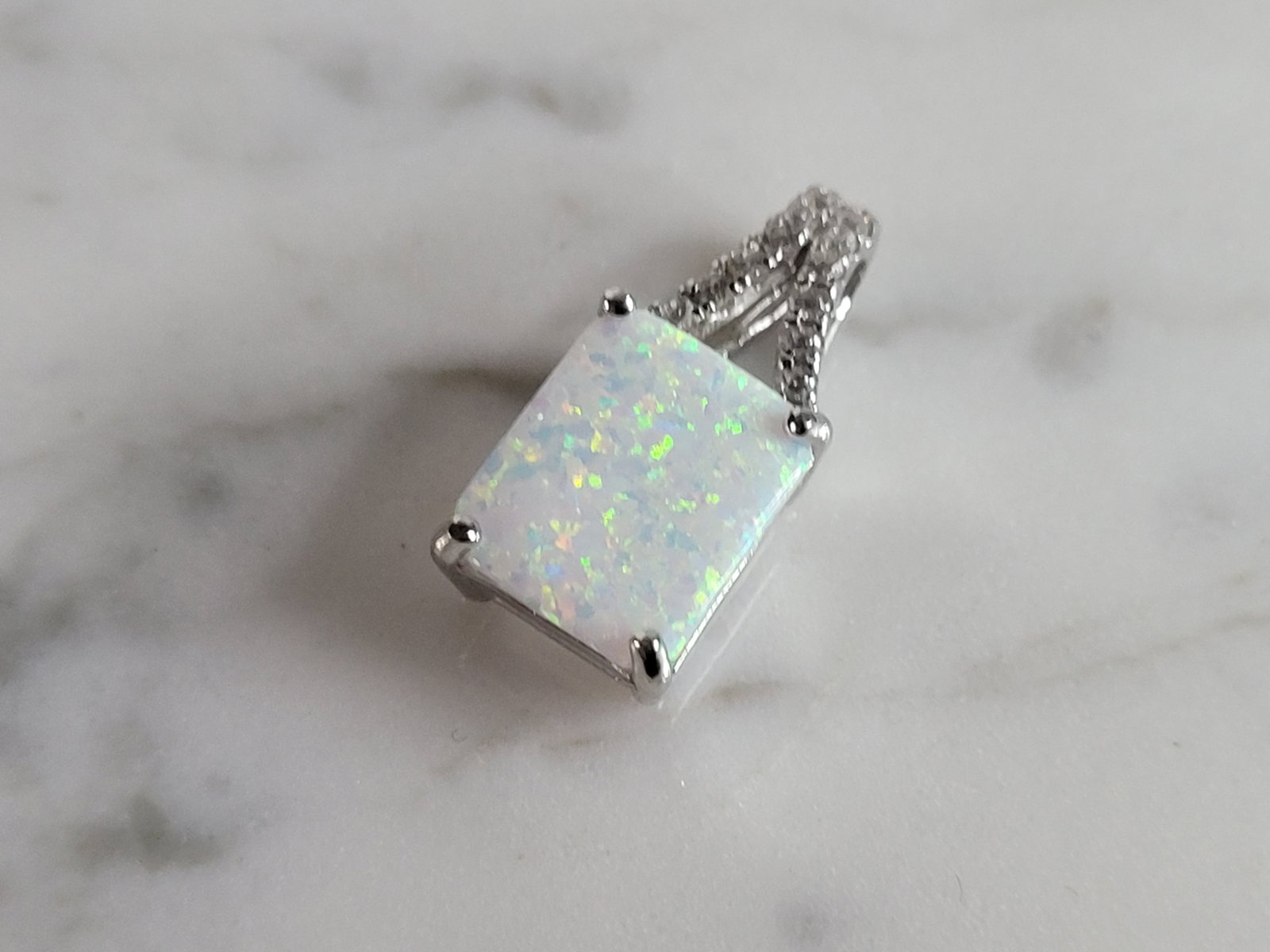 Womens Sterling Silver Modernist Opal Stone Pendant: A WOMENS STERLING SILVER MODERNIST OPAL STONE PENDANT. NOT SURE IF STONES ARE REAL OR MAN MADE. THE PENDANT WEIGHS 2.1g AND MEASURES 3/4" LONG BY 3/8" WIDE. MAKES A GREAT GIFT FOR THAT SOMEONE SPECIAL