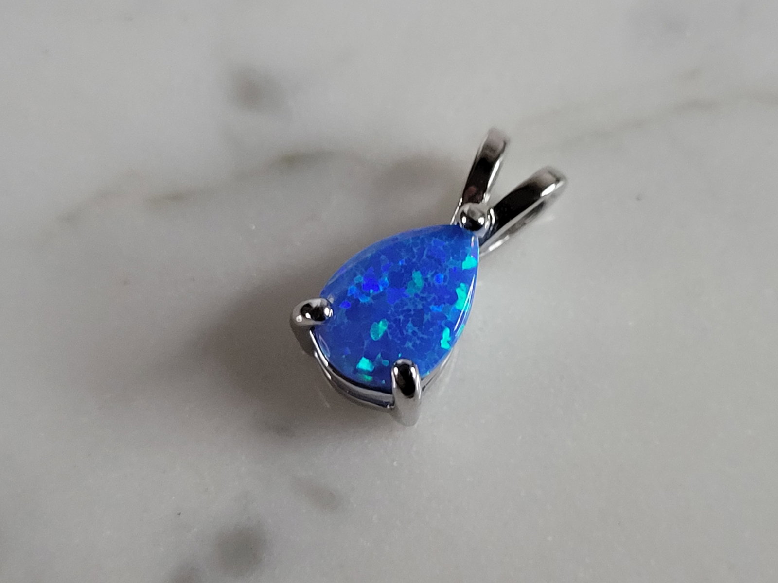 Womens Sterling Silver Blue Opal Modernist Pendant: A WOMENS STERLING SILVER BLUE OPAL MODERNIST PENDANT. NOT SURE IF STONES ARE REAL OR MAN MADE. THE PENDANT WEIGHS 0.9g AND MEASURES 1/2" LONG BY 1/4" WIDE. MAKES A GREAT GIFT FOR THAT SOMEONE SPECIAL.
