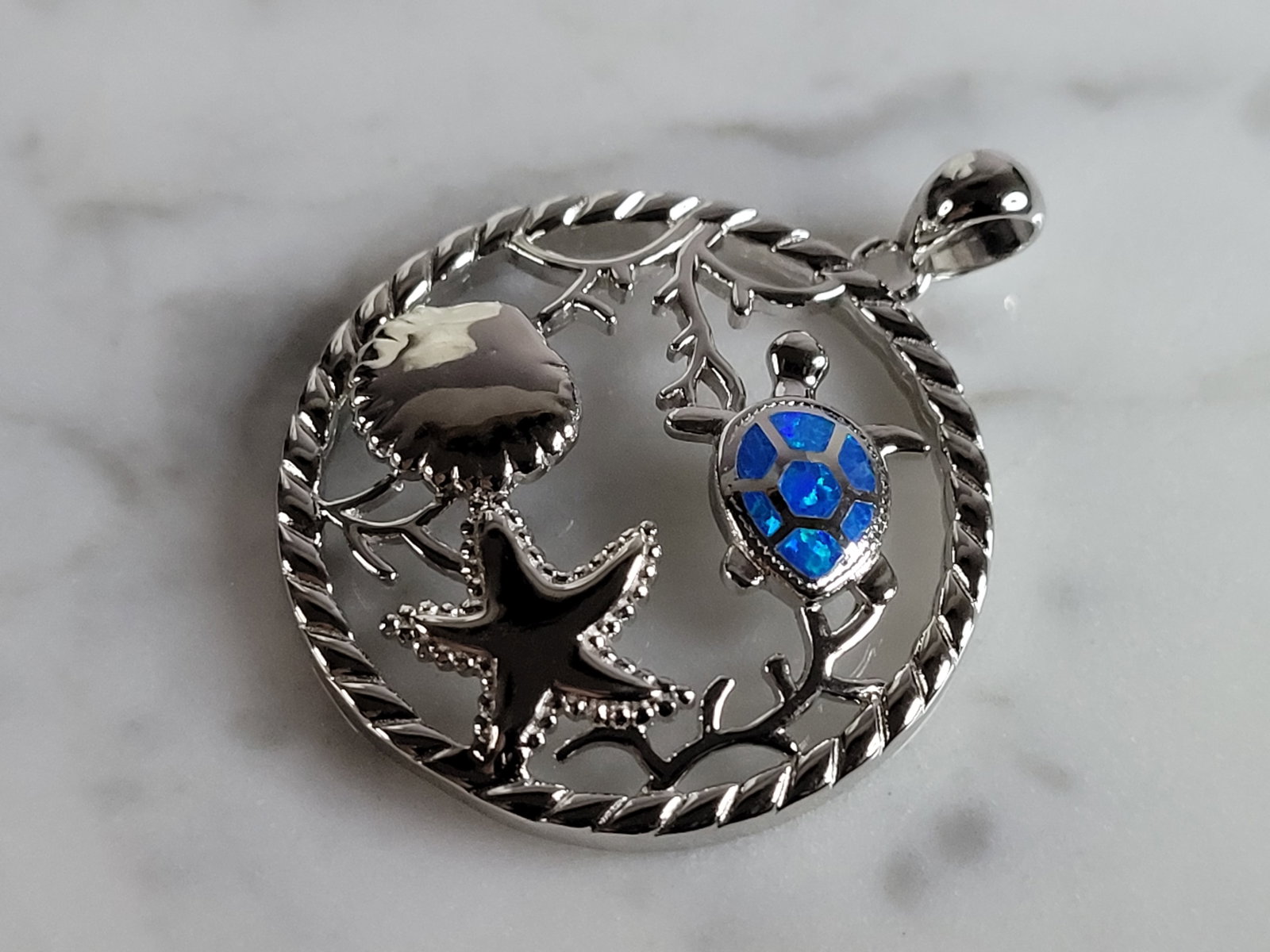Womens Sterling Silver Blue Opal Turtle Star Fish Pendant: A WOMENS STERLING SILVER BLUE OPAL TURTLE AND STAR FISH PENDANT. NOT SURE IF STONES ARE REAL OR MAN MADE. THE PENDANT WEIGHS 6.2g AND MEASURES 1 1/4" LONG BY 1" WIDE. MAKES A GREAT GIFT FOR THAT SOMEO