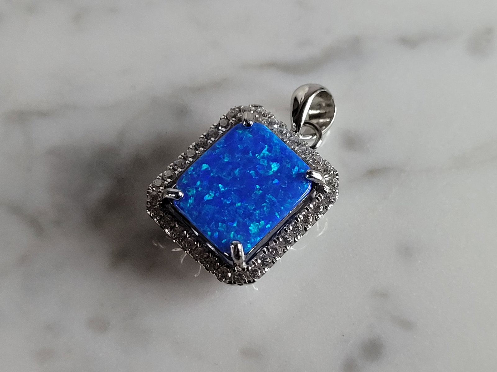 Womens Sterling Silver Blue Opal Modernist Pendant: A WOMENS STERLING SILVER BLUE OPAL MODERNIST PENDANT. NOT SURE IF STONES ARE REAL OR MAN MADE. THE PENDANT WEIGHS 2.9g AND MEASURES 7/8" LONG BY 1/2" WIDE. MAKES A GREAT GIFT FOR THAT SOMEONE SPECIAL.