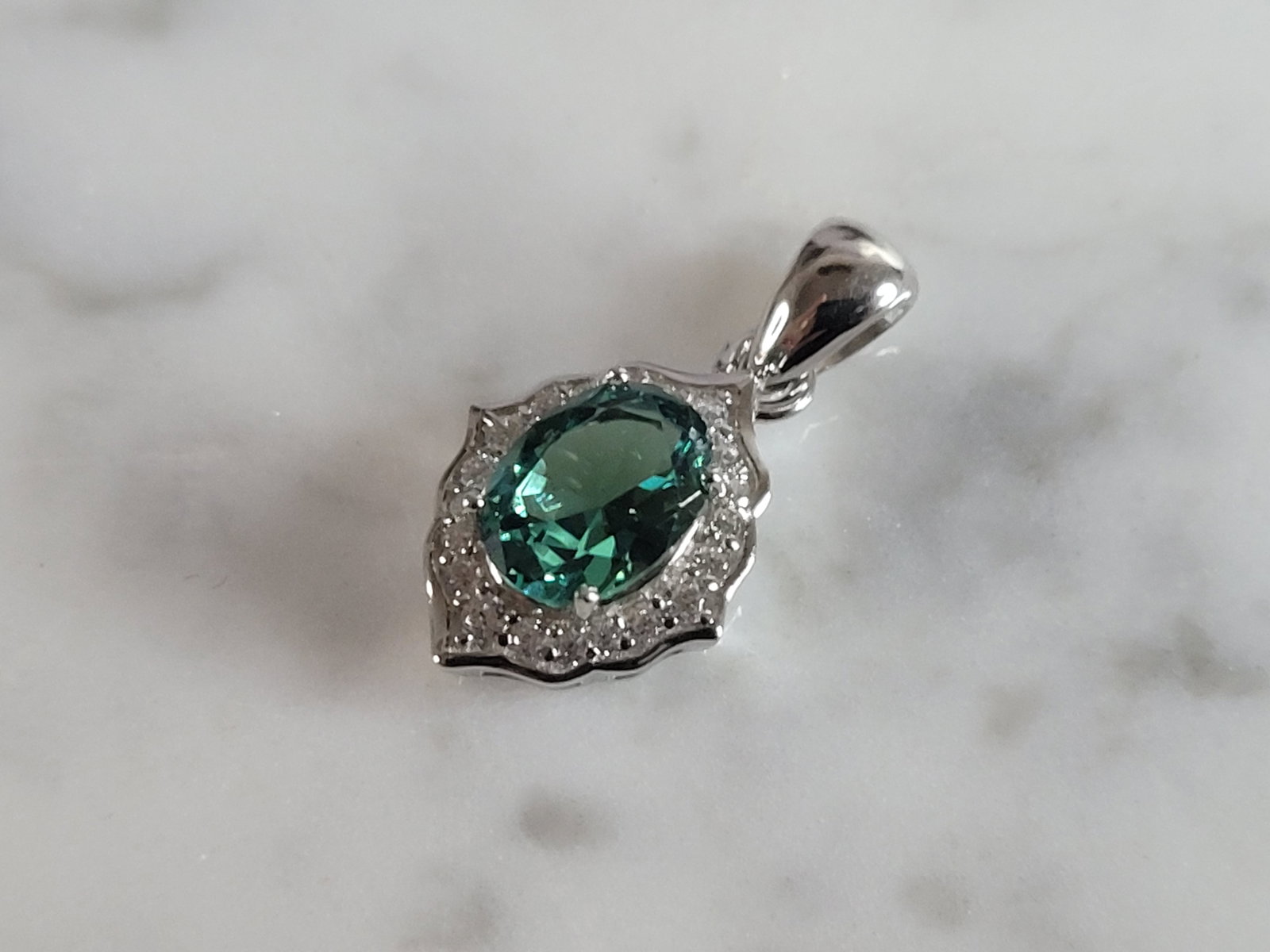 Womens Sterling Silver Modernist CZ Pendant: A WOMENS STERLING SILVER MODERNIST CZ PENDANT WITH AN EMERALD COLORED STONE. PENDANT WEIGHS 2.3g AND MEASURES 3/4" LONG BY 3/8" WIDE. MAKES A GREAT GIFT FOR THAT SOMEONE SPECIAL. ANY QUESTIONS, PLEASE