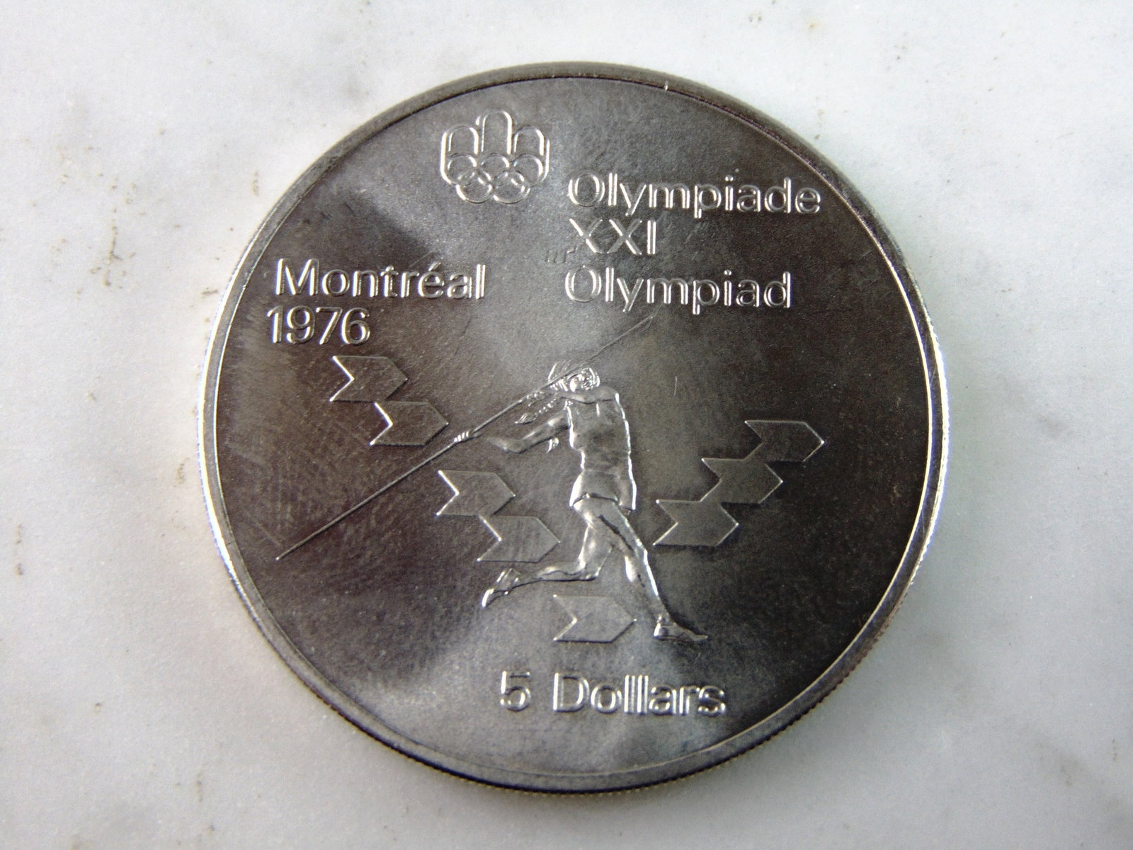 1975 $5 Canadian '76 Montreal Summer Olympics Silver Coin: FOR SALE IS THIS 1975 $5 CANADIAN '76 MONTREAL SUMMER OLYMPICS SILVER COIN. COIN APPEARS TO BE IN VERY GOOD CONDITION, UNC , HOWEVER WE ARE NOT COIN EXPERTS WHEN IT COMES TO PROPER GRADING. PICTURES S