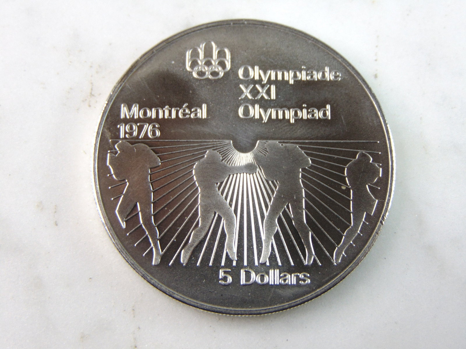 1976 $5 Canadian '76 Montreal Summer Olympics Silver Coin: FOR SALE IS THIS 1976 $5 CANADIAN '76 MONTREAL SUMMER OLYMPICS SILVER COIN. COIN APPEARS TO BE IN VERY GOOD CONDITION, UNC , HOWEVER WE ARE NOT COIN EXPERTS WHEN IT COMES TO PROPER GRADING. PICTURES S