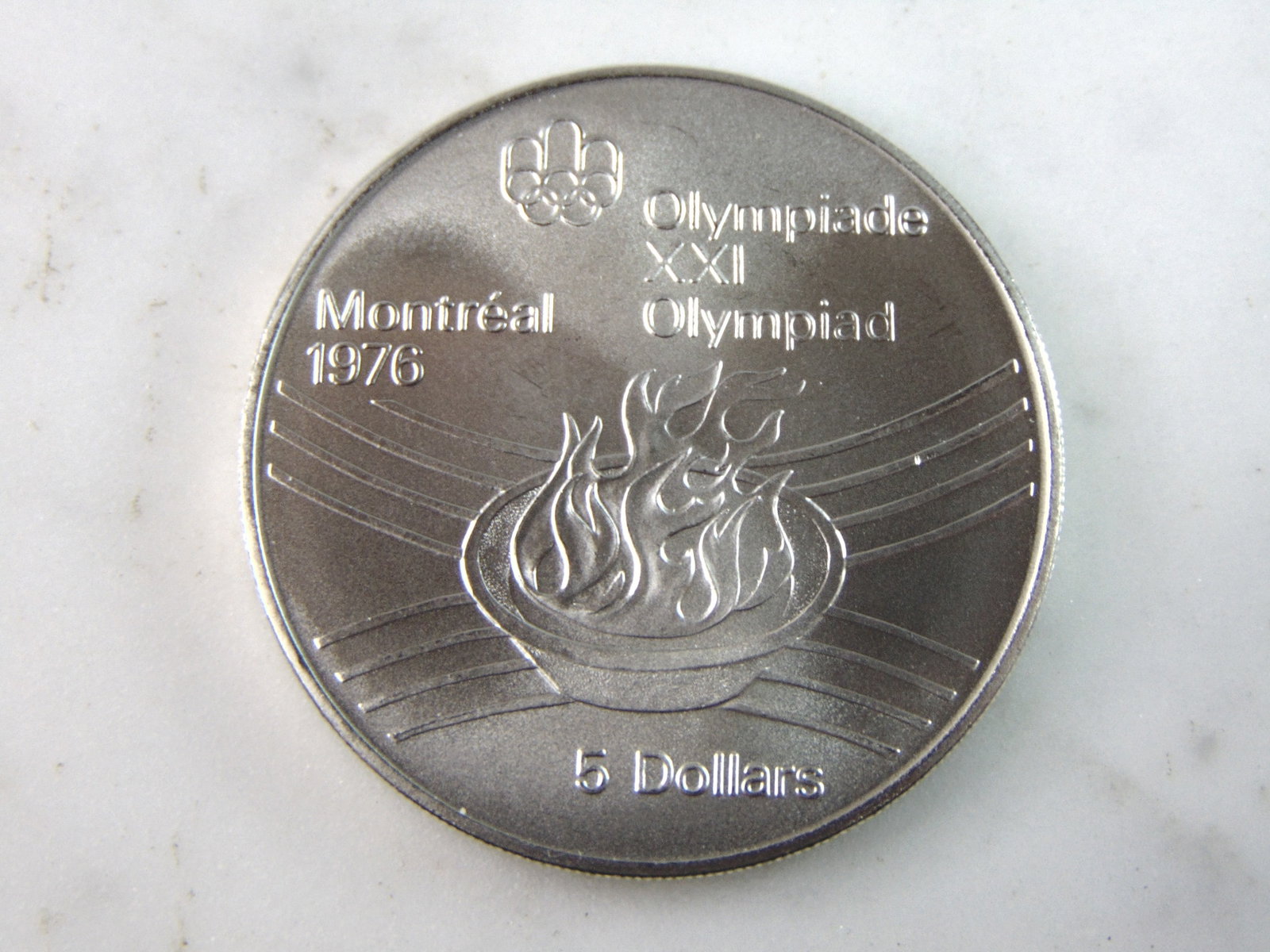1976 $5 Canadian '76 Montreal Summer Olympics Silver Coin: FOR SALE IS THIS 1976 $5 CANADIAN '76 MONTREAL SUMMER OLYMPICS SILVER COIN. COIN WEIGHS 24.2g. COIN APPEARS TO BE IN VERY GOOD CONDITION, UNC , HOWEVER WE ARE NOT COIN EXPERTS WHEN IT COMES TO PROPER