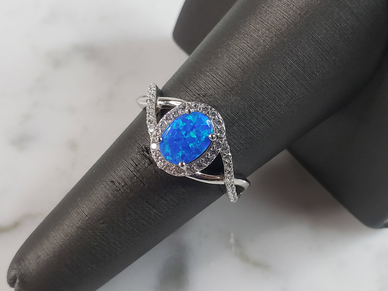 Womens Estate Sterling Silver Modernist Blue Opal & CZ Ring: A WOMENS ESTATE STERLING SILVER MODERNIST BLUE OPAL COLORED RING. THE RING IS A SIZE 7.5 AND WEIGHS 3.4g. WIDTH OF RING MEASURES 3/8". NOT SURE IF STONE IS NATURAL OR MAN MADE. THE RING MAKES A BEAUTI