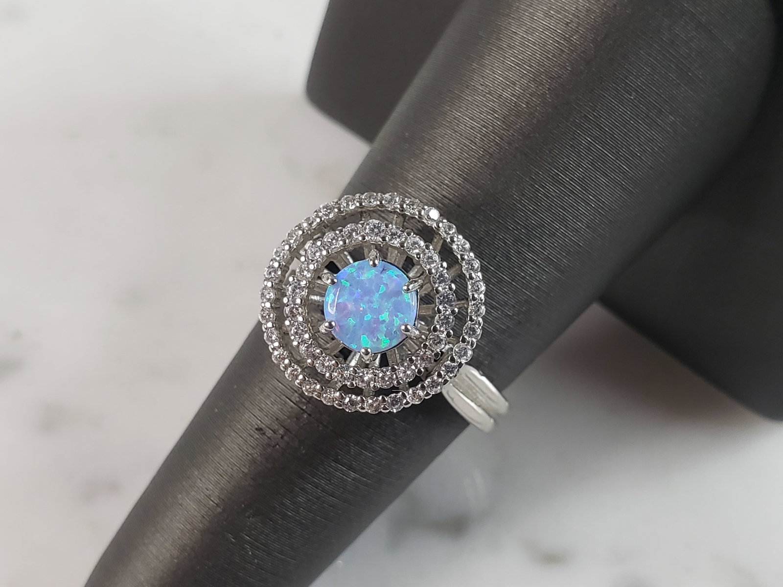 Womens Estate Sterling Silver Modernist Blue Opal & CZ Ring: A WOMENS ESTATE STERLING SILVER MODERNIST BLUE OPAL COLORED RING. THE RING IS A SIZE 8.0 AND WEIGHS 4.1g. WIDTH OF RING MEASURES 5/8". NOT SURE IF STONE IS NATURAL OR MAN MADE. THE RING MAKES A BEAUTI