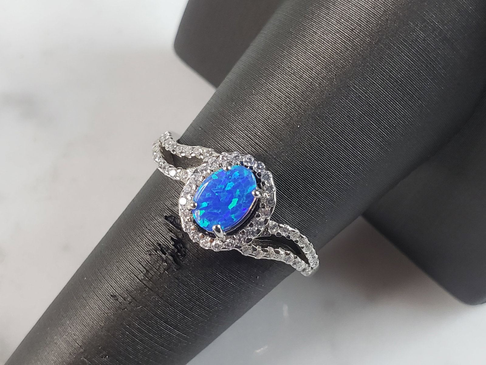 Womens Sterling Silver Modernist Blue Opal & CZ Ring: A WOMENS STERLING SILVER MODERNIST BLUE OPAL COLORED RING. THE RING IS A SIZE 7.25, AND WEIGHS 2.2g. WIDTH OF RING MEASURES 3/8". NOT SURE IF STONE IS NATURAL OR MAN MADE. THE RING MAKES A BEAUTIFUL G