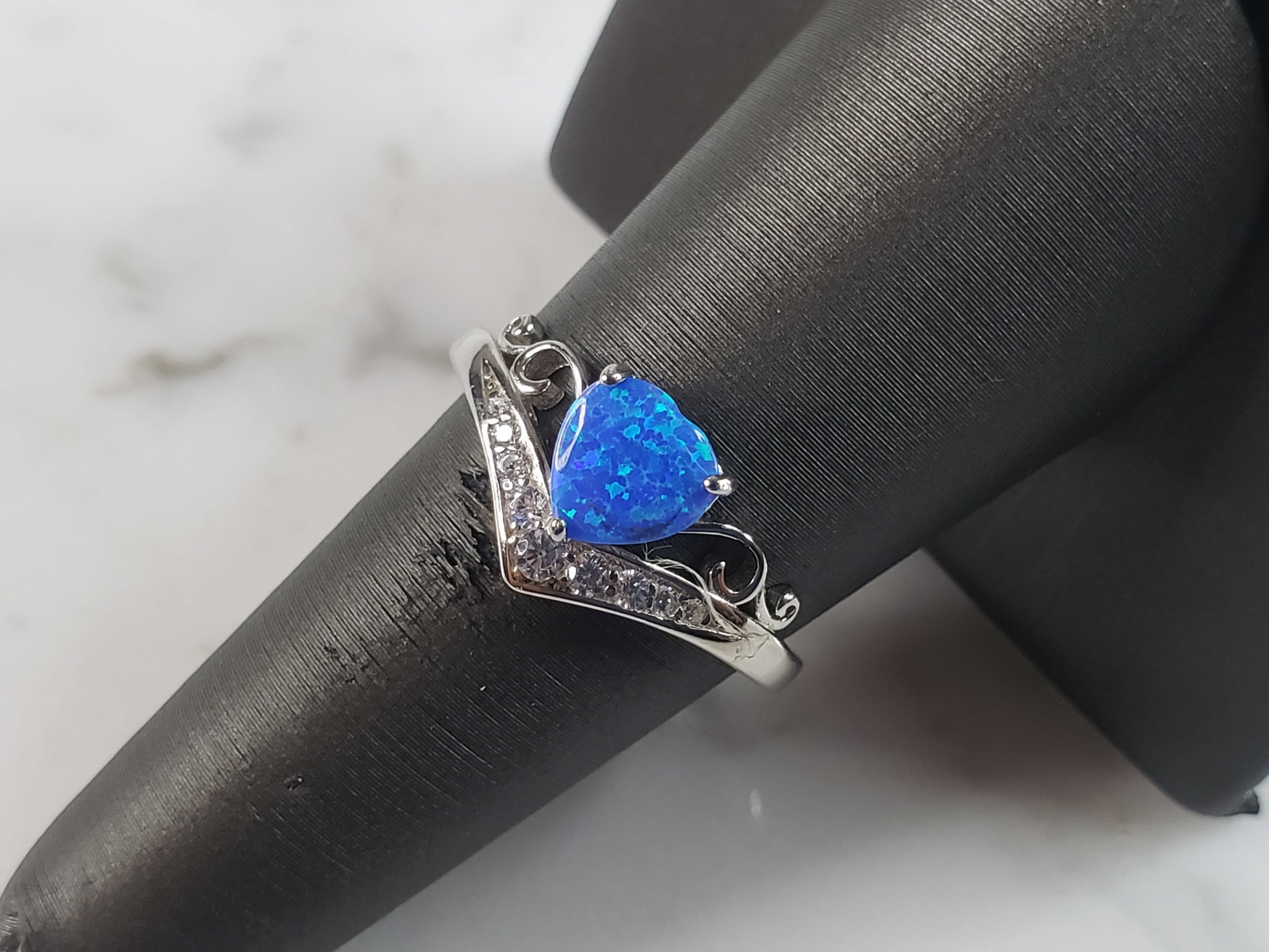 Womens Sterling Silver Modernist Blue Opal Heart Ring: A WOMENS STERLING SILVER MODERNIST BLUE OPAL COLORED RING. THE RING IS A SIZE 7.0, AND WEIGHS 3.1g. WIDTH OF RING MEASURES 3/8". NOT SURE IF STONE IS NATURAL OR MAN MADE. THE RING MAKES A BEAUTIFUL GI